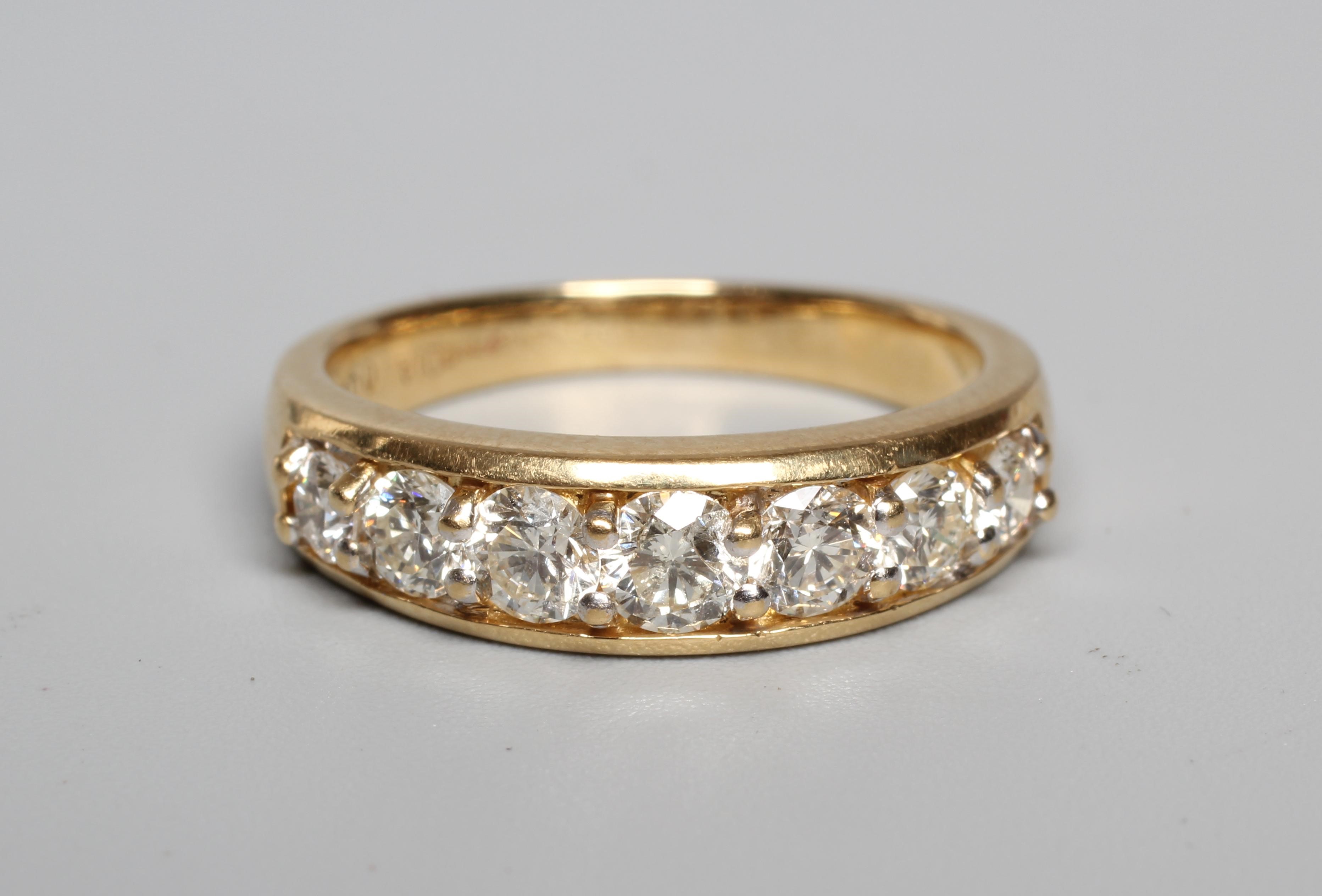 A SEVEN STONE DIAMOND HALF HOOP RING, the graduated round brilliants point set to a plain 18ct gold Image