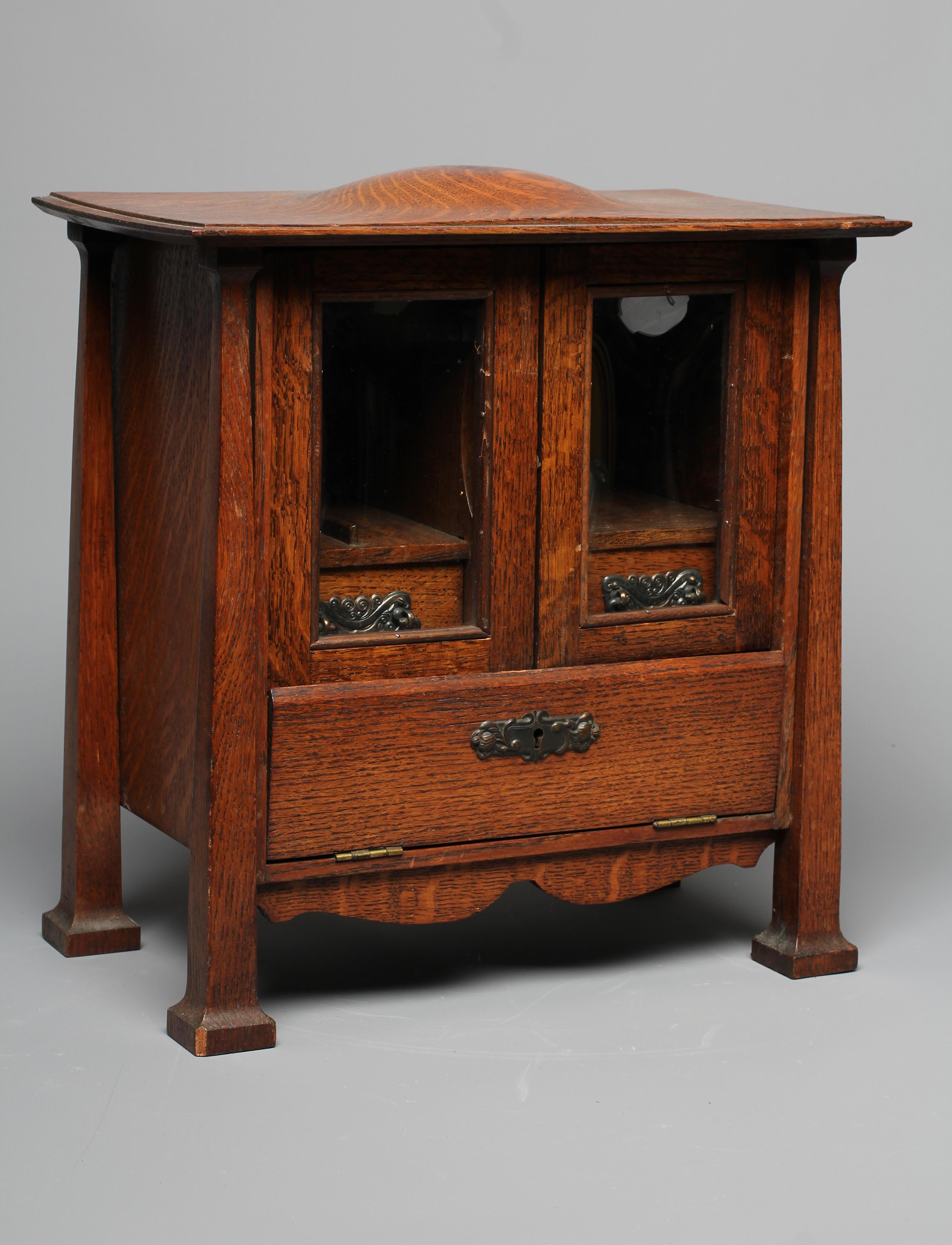 AN ARTS AND CRAFTS OAK SMOKER'S CABINET Image