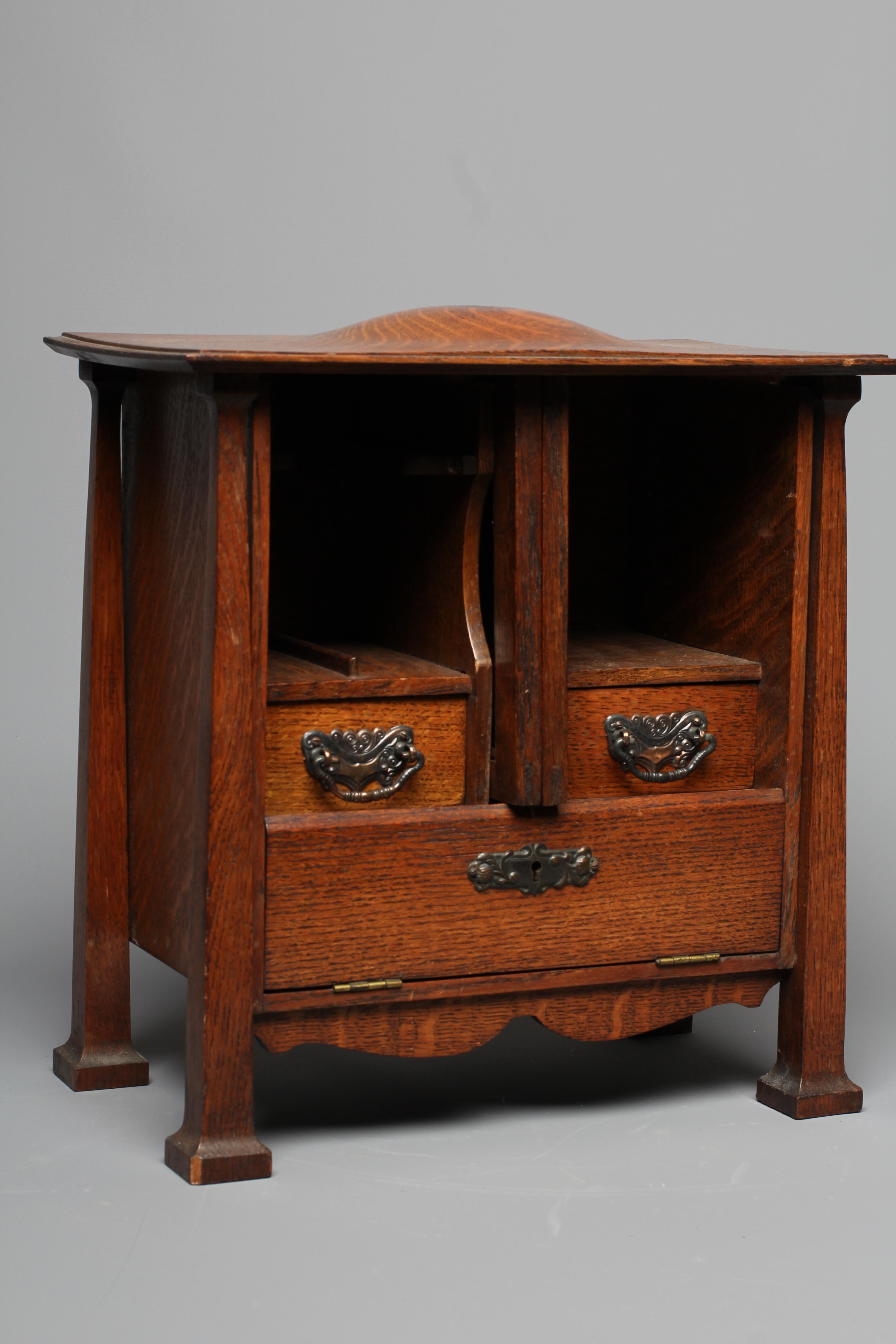 AN ARTS AND CRAFTS OAK SMOKER'S CABINET Image