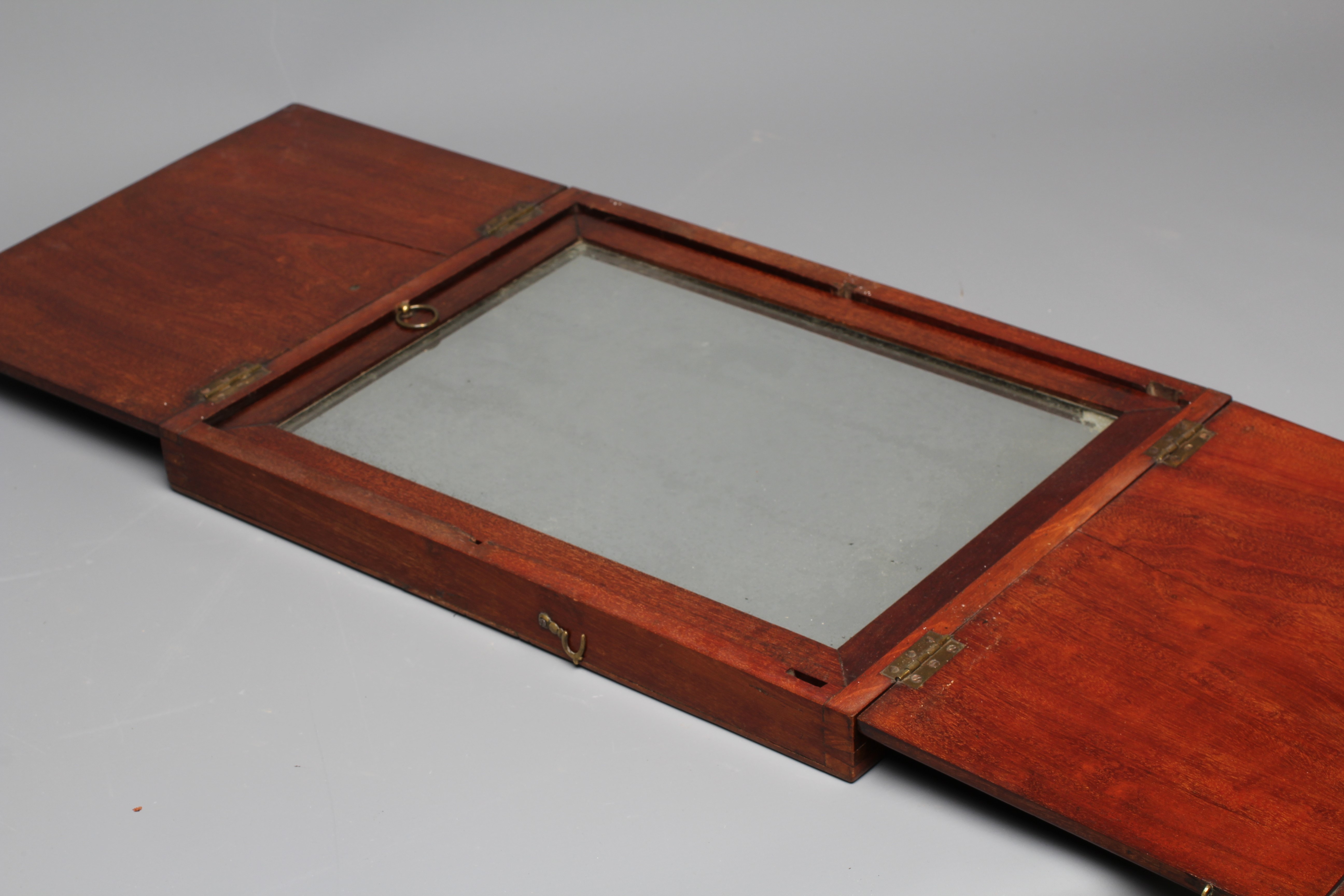 A 19TH CENTURY FOLDING CAMPAIGN MIRROR, the oblong plate in a moulded frame folding into a Image