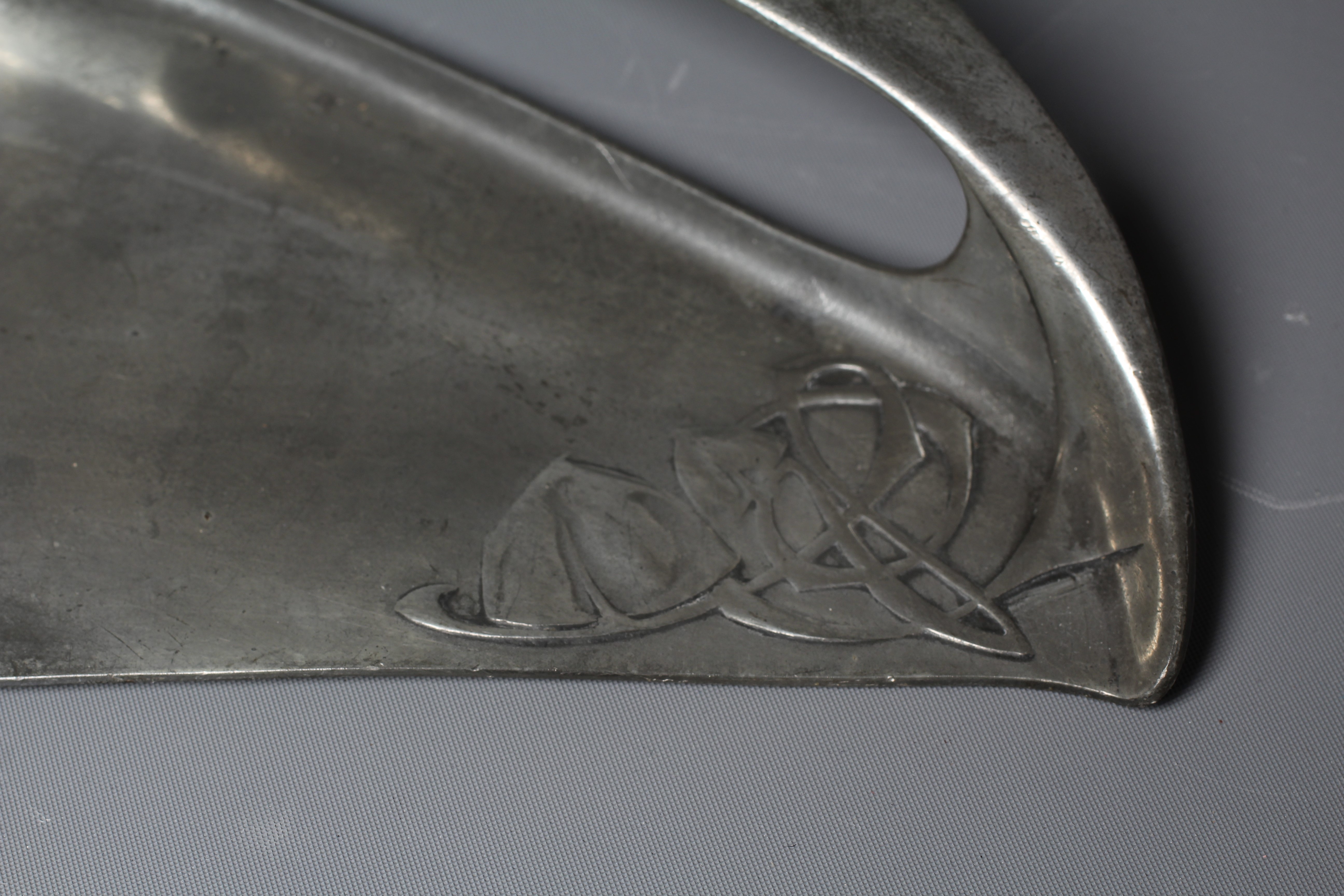 ARCHIBALD KNOX FOR LIBERTY & CO. - An English Pewter demi-lune crumb tray cast with two panels of Image