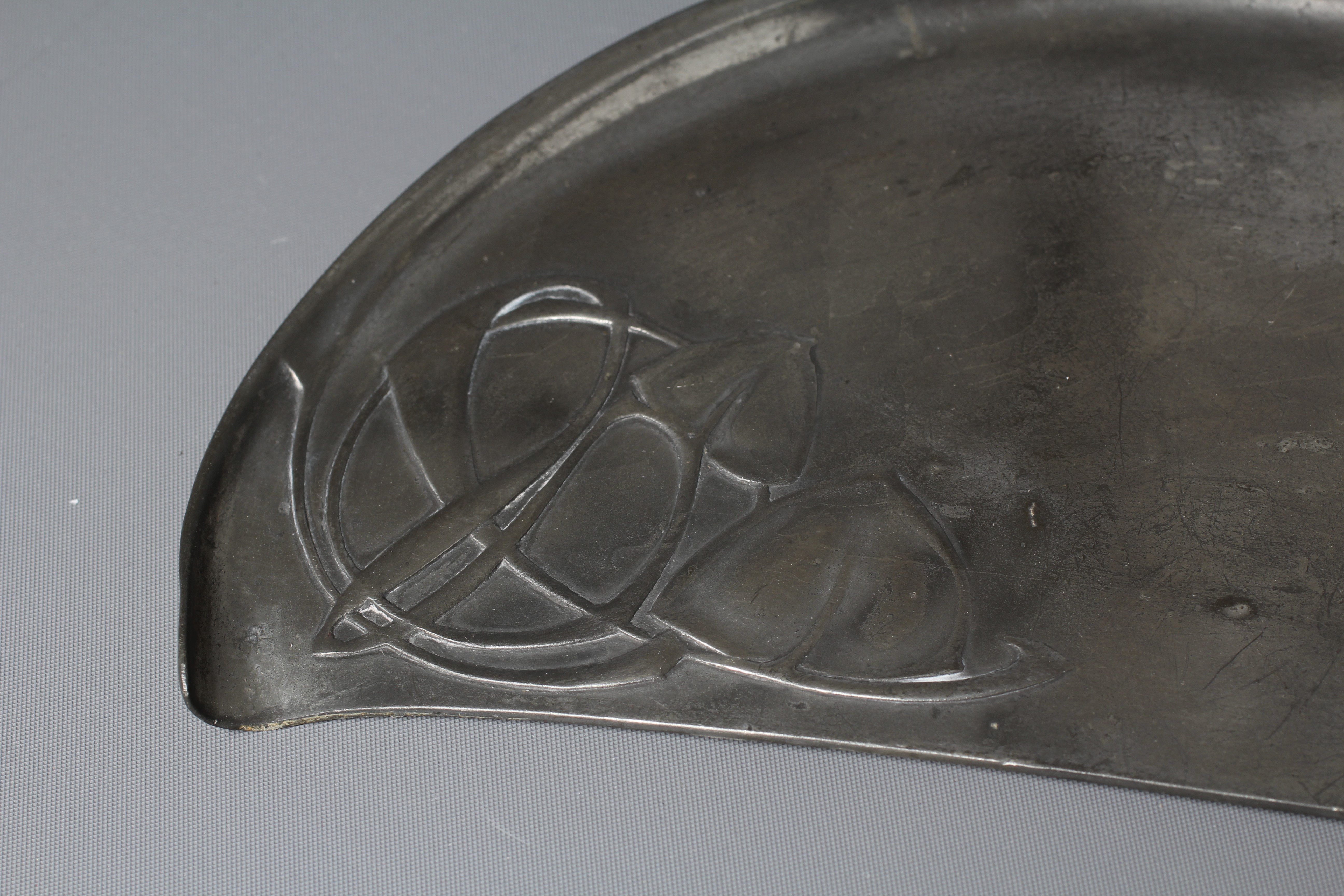ARCHIBALD KNOX FOR LIBERTY & CO. - An English Pewter demi-lune crumb tray cast with two panels of Image