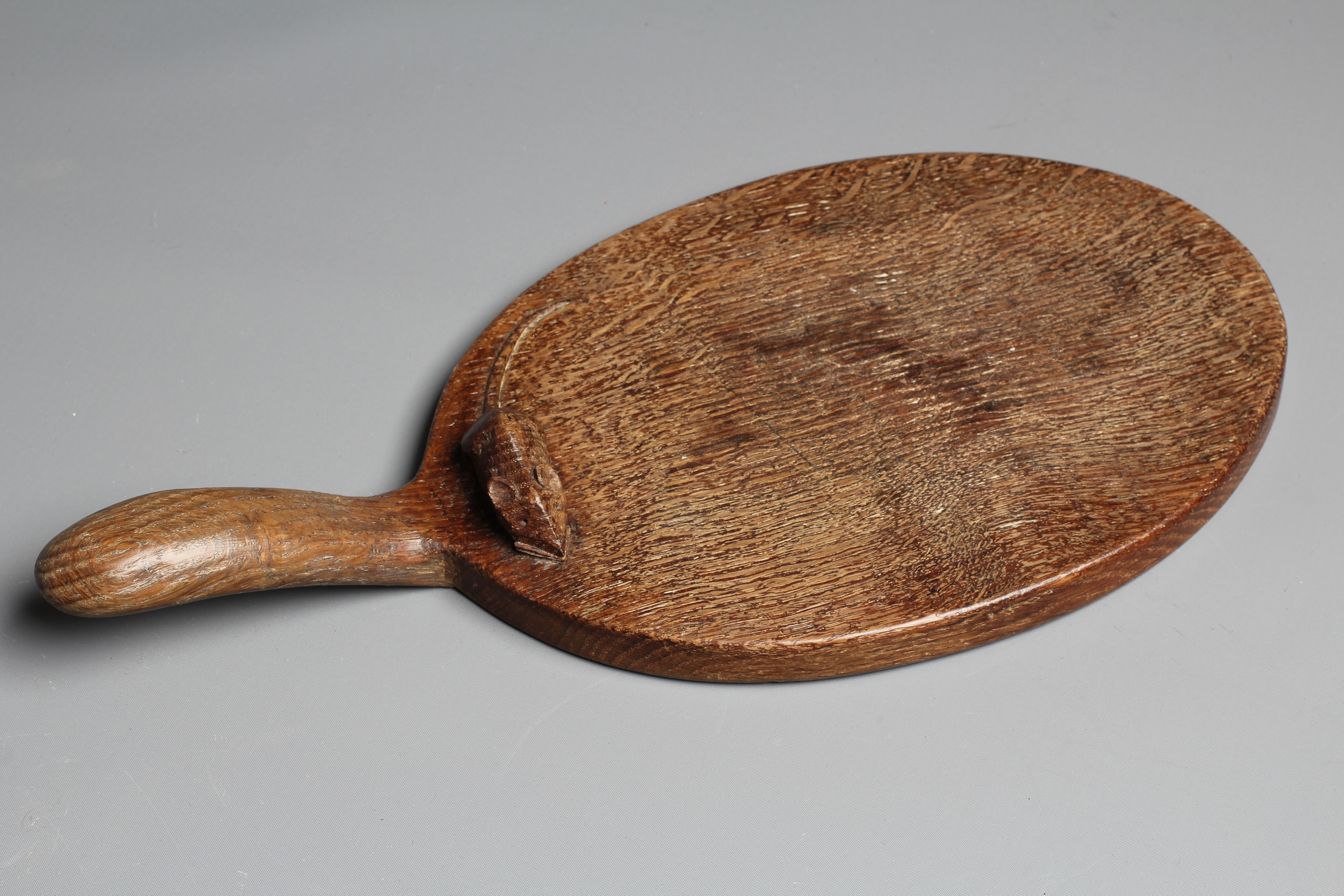 A ROBERT THOMPSON OAK CHEESE BOARD with carved mouse trademark to the handle, 14 3/4" Image