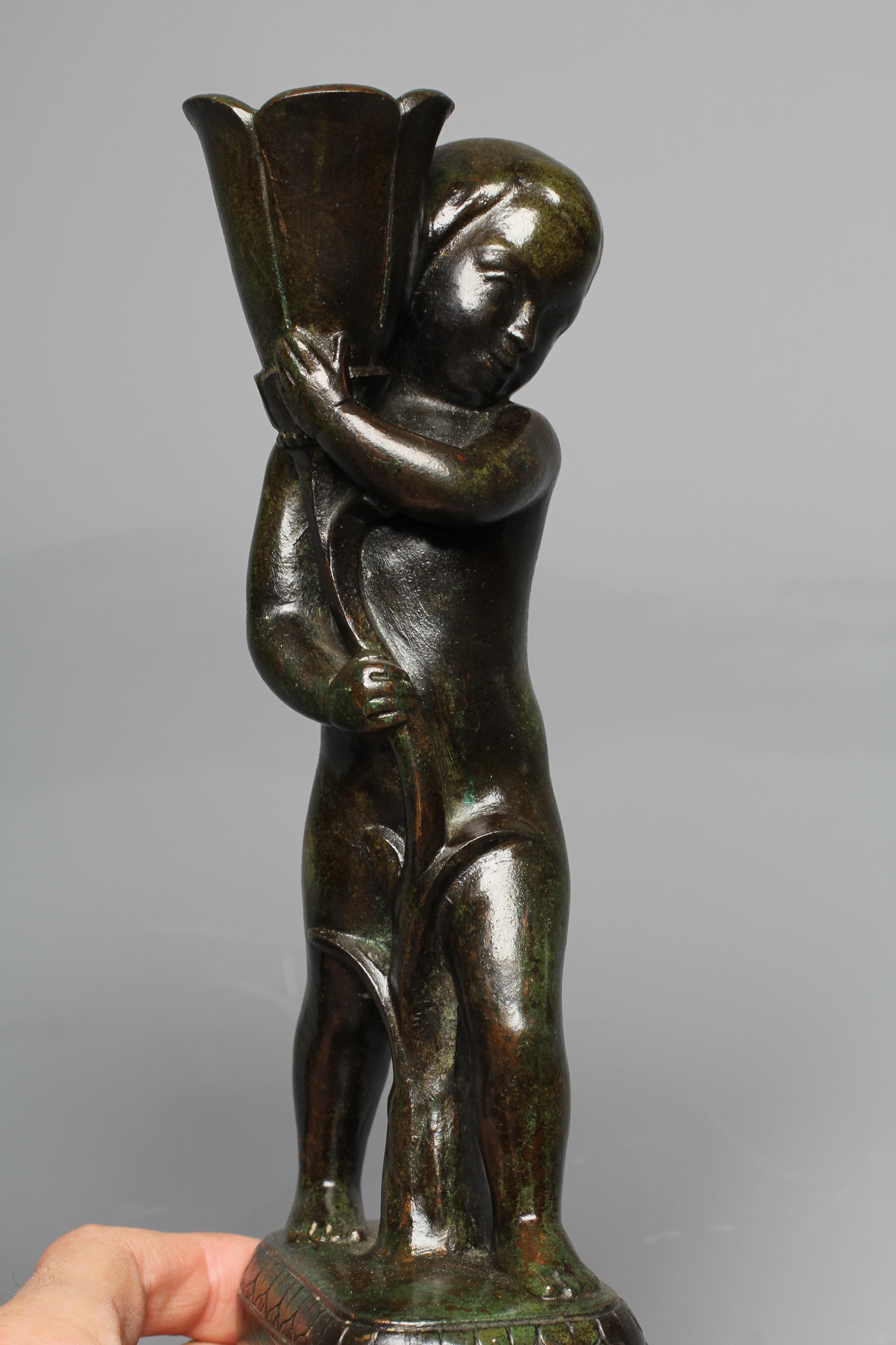 STYLE OF PIERRE TRAVERSE (1892-1979) A pair of candlesticks modelled as children holding stylised Image