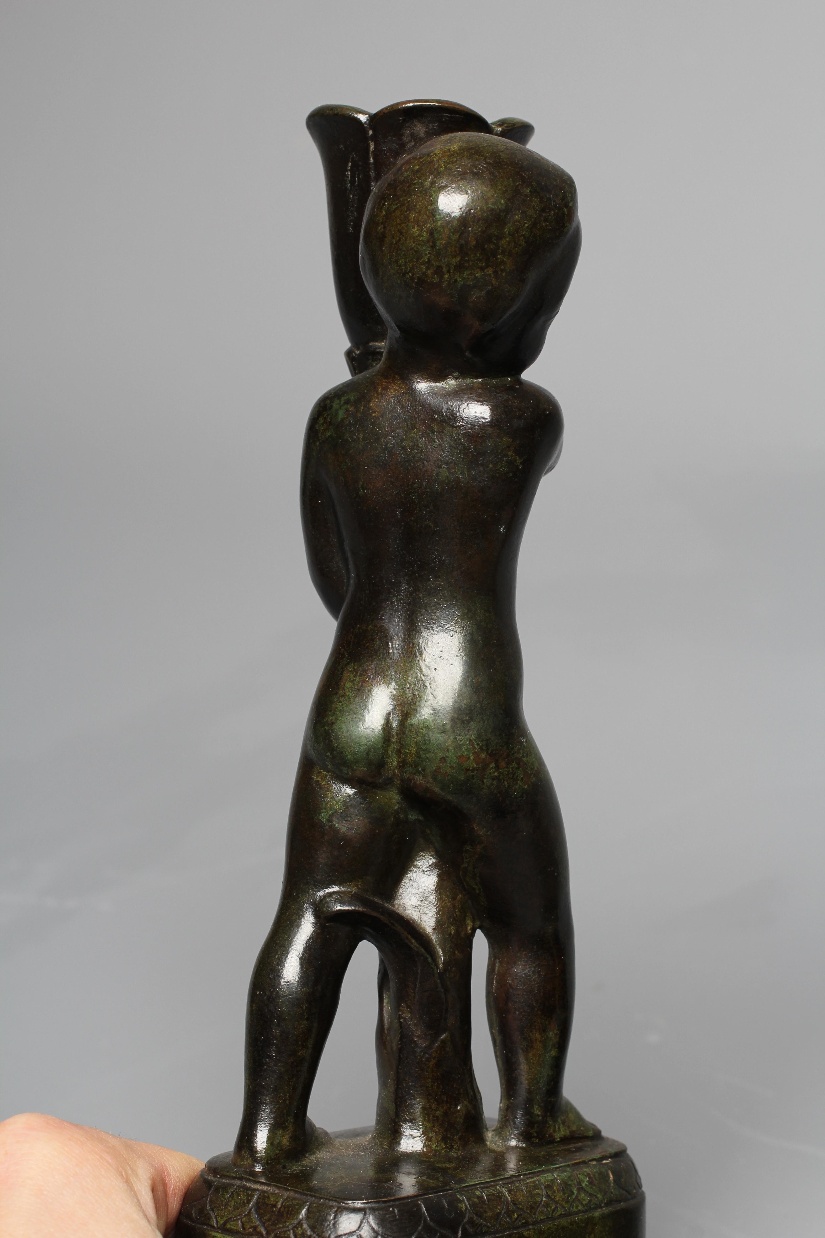 STYLE OF PIERRE TRAVERSE (1892-1979) A pair of candlesticks modelled as children holding stylised Image