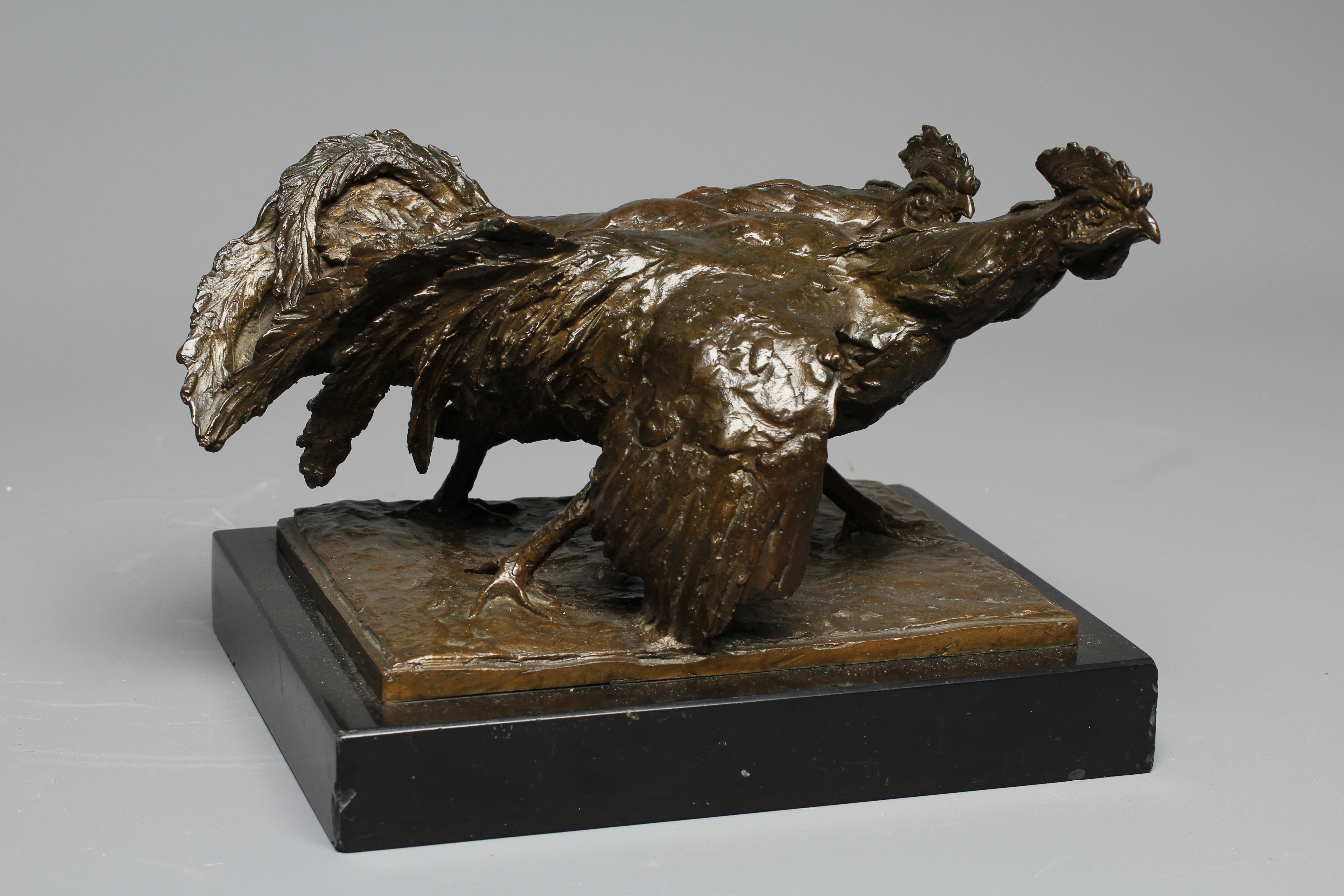 A 20TH CENTURY BRONZE OF TWO COCKERELS FIGHTING with dark brown patina, on an oblong polished slate Image