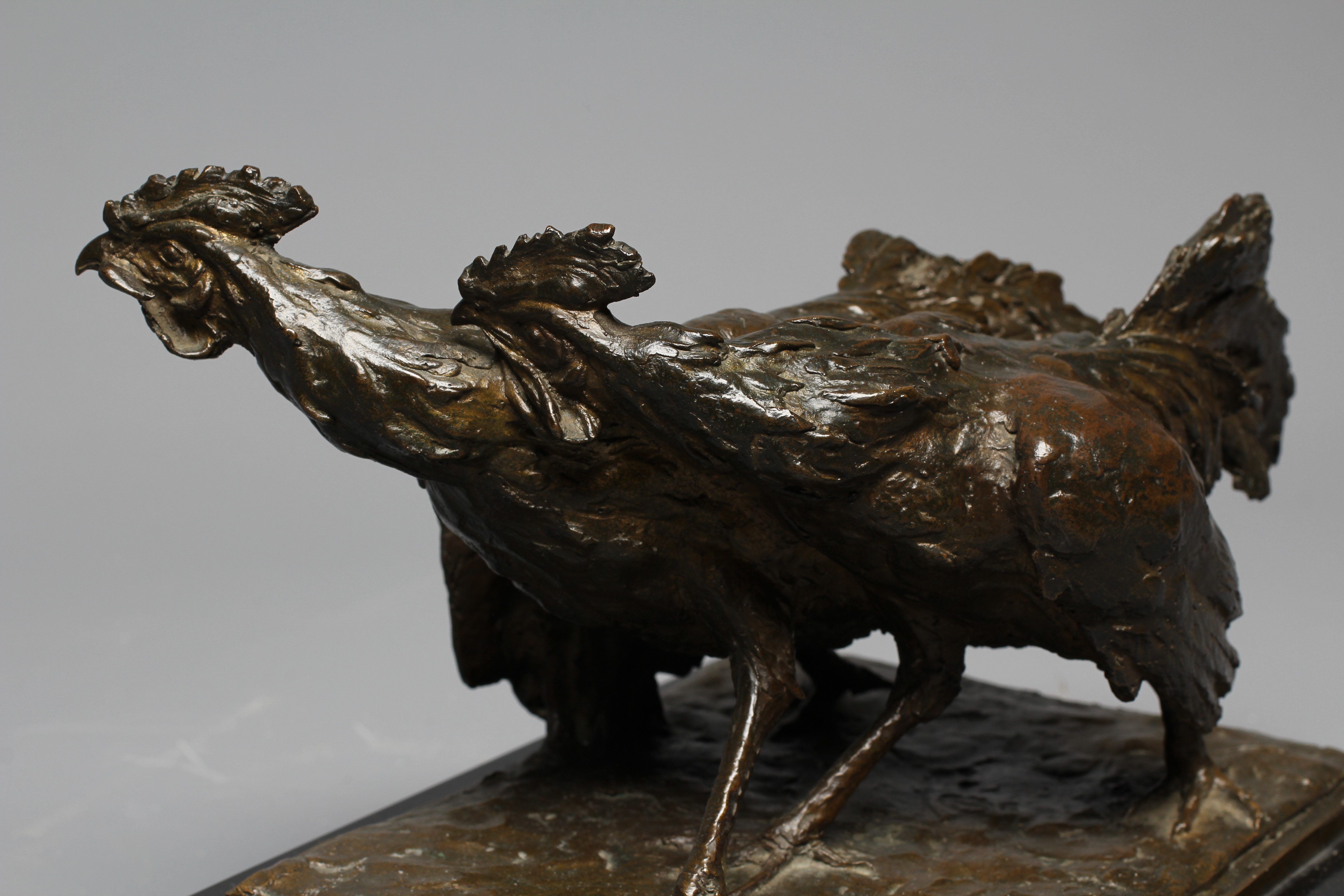 A 20TH CENTURY BRONZE OF TWO COCKERELS FIGHTING with dark brown patina, on an oblong polished slate Image