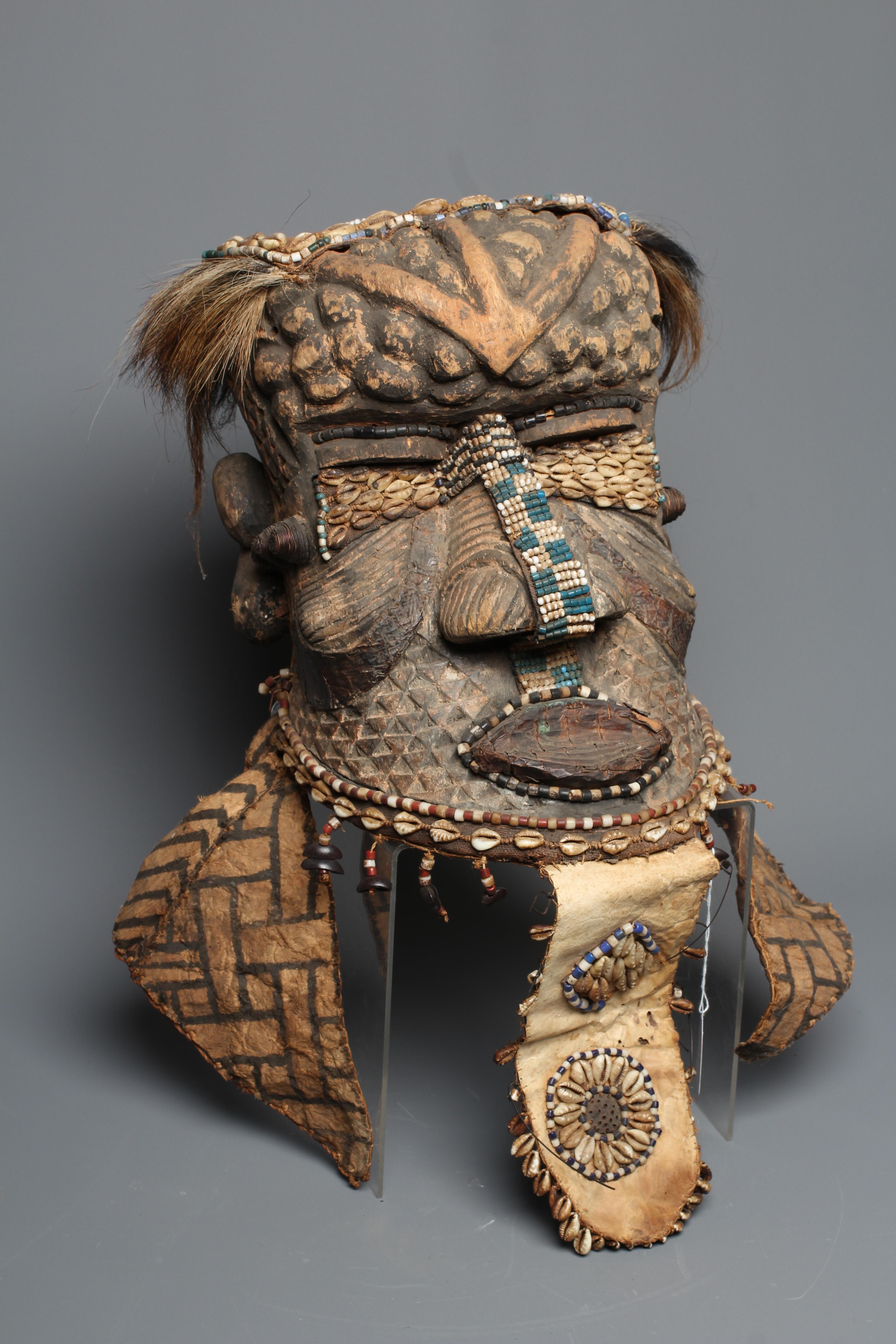 A KUBA BWOOM MASK, Congo, wood, hide, cloth and hair, with shell and bead decoration, 12" high Image