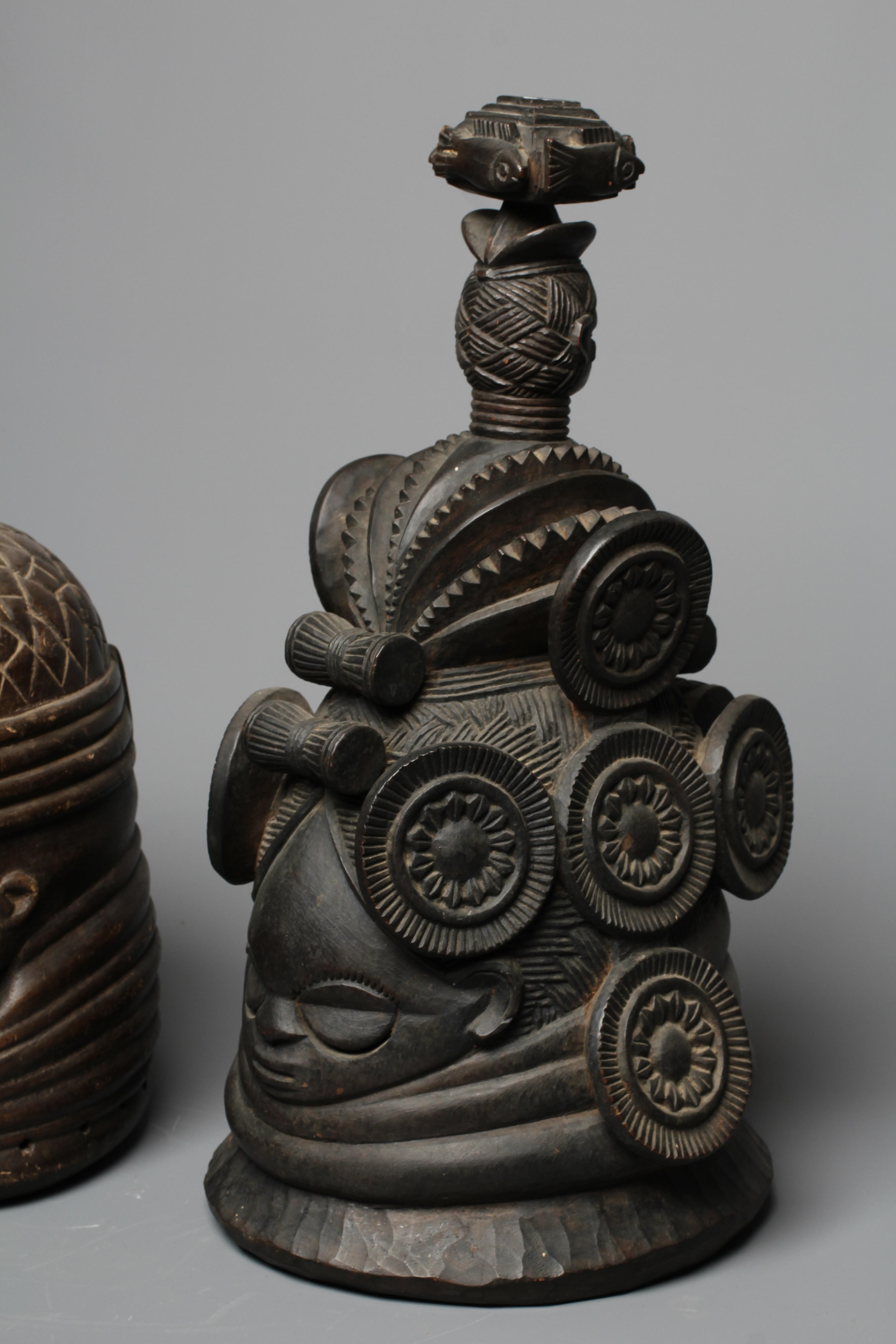 A MENDE HELMET MASK, Sierra Leone, heavily carved wood, 13 1/2", together with another Mende helmet Image