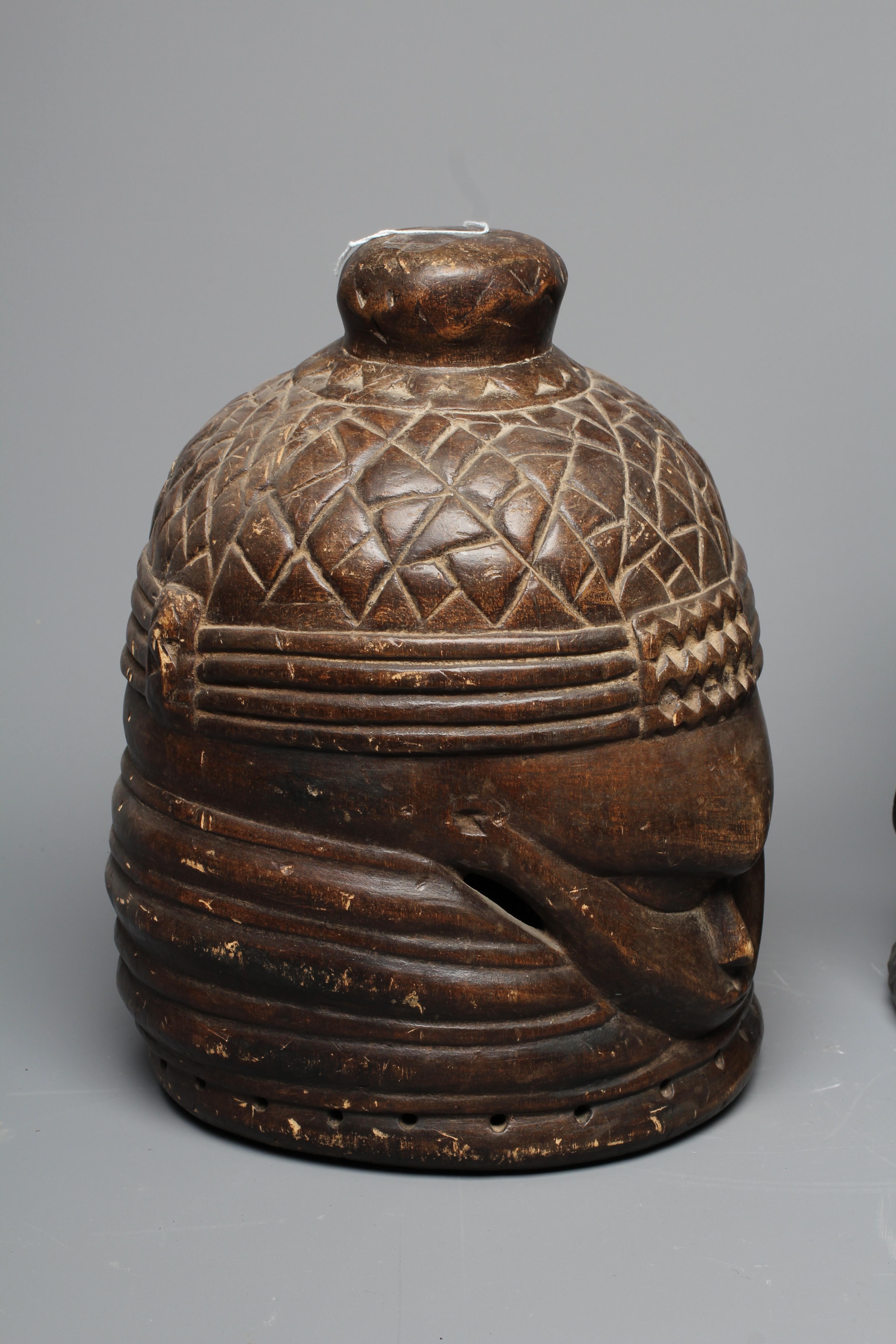 A MENDE HELMET MASK, Sierra Leone, heavily carved wood, 13 1/2", together with another Mende helmet Image