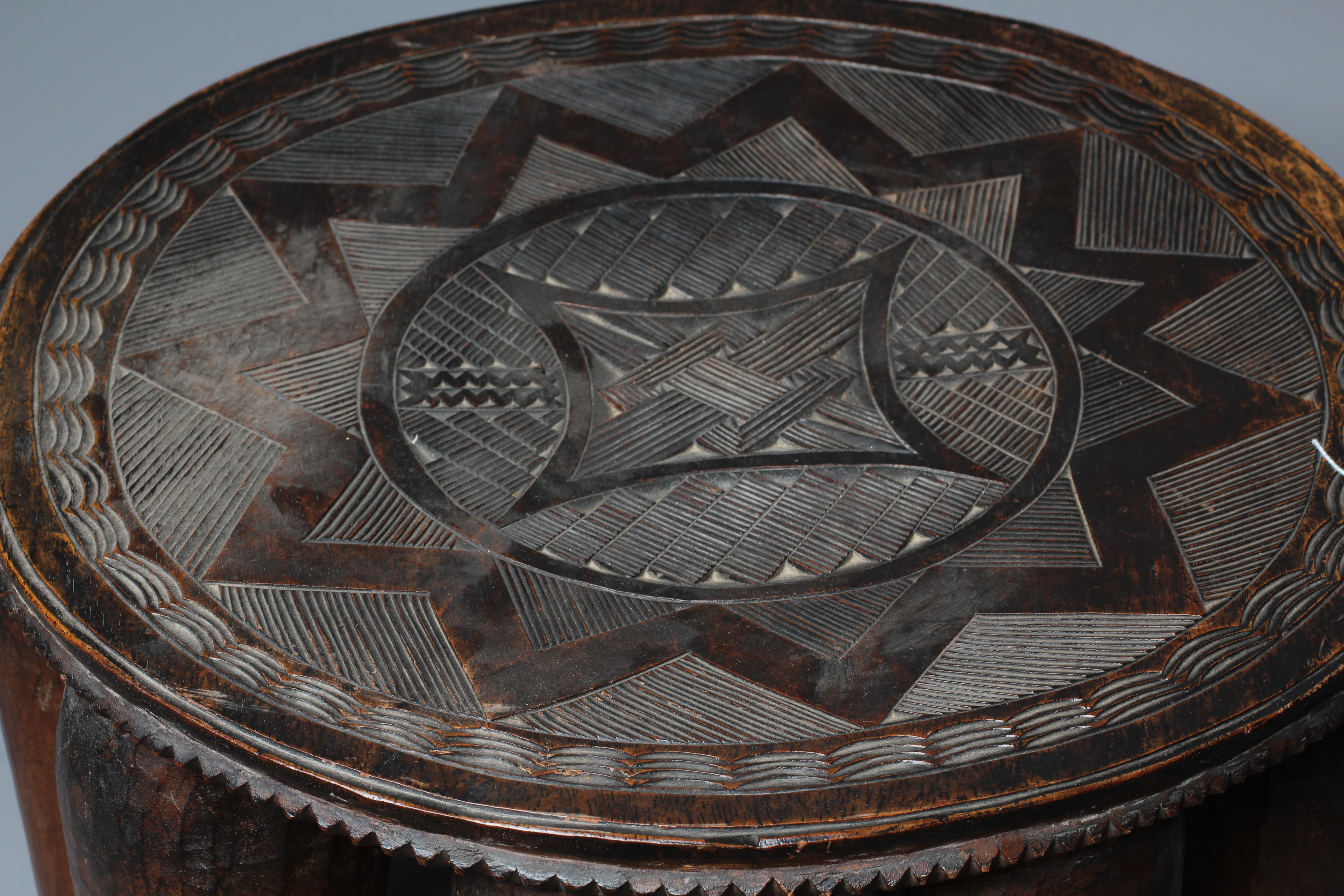 A NUPE TRIBAL STOOL, the circular top decorated with a geometric design raised on ten circular Image