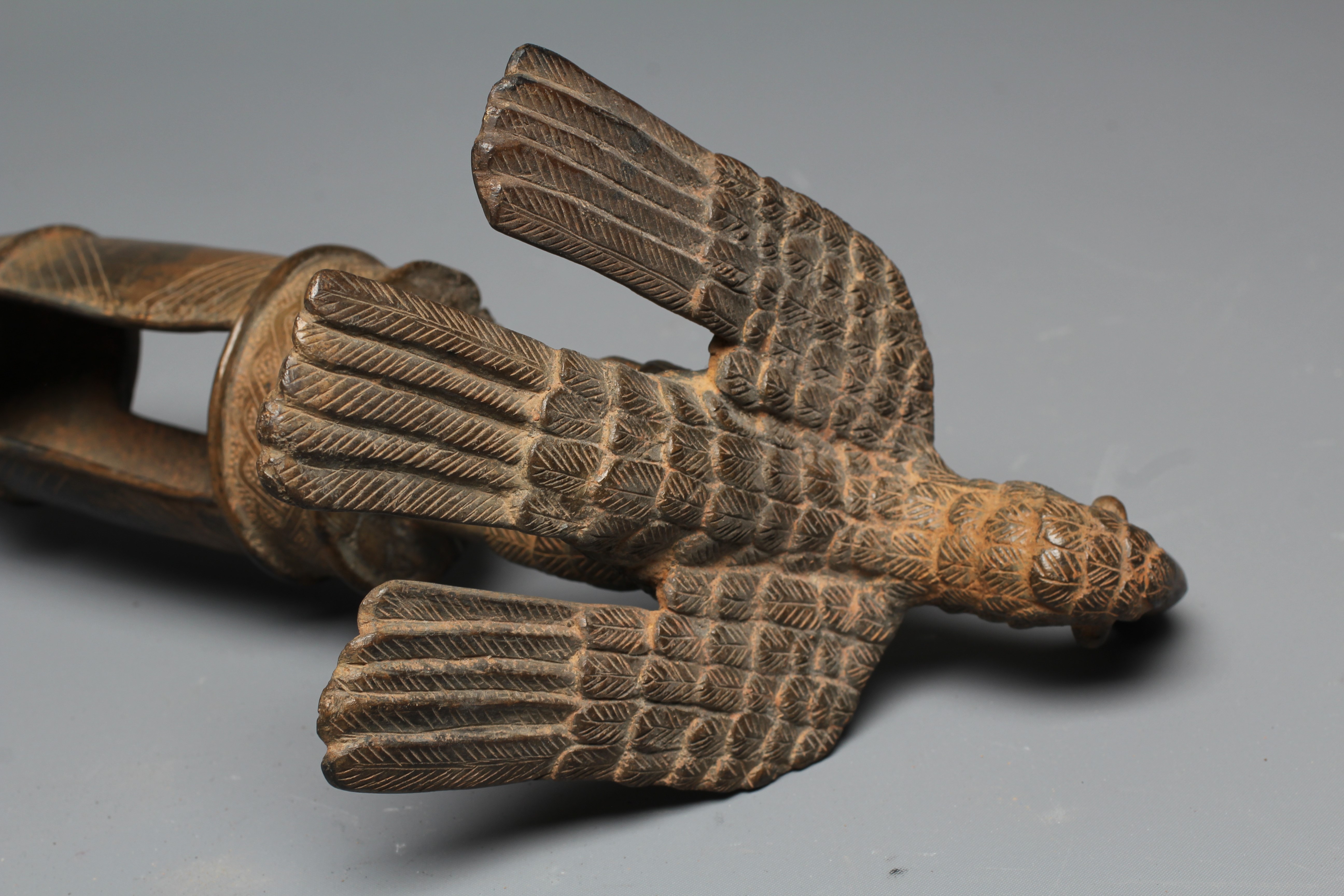 A BENIN BRASS IDIOPHONE, brass, iron, with pierced cylindrical shaft, surmounted a long-billed bird Image