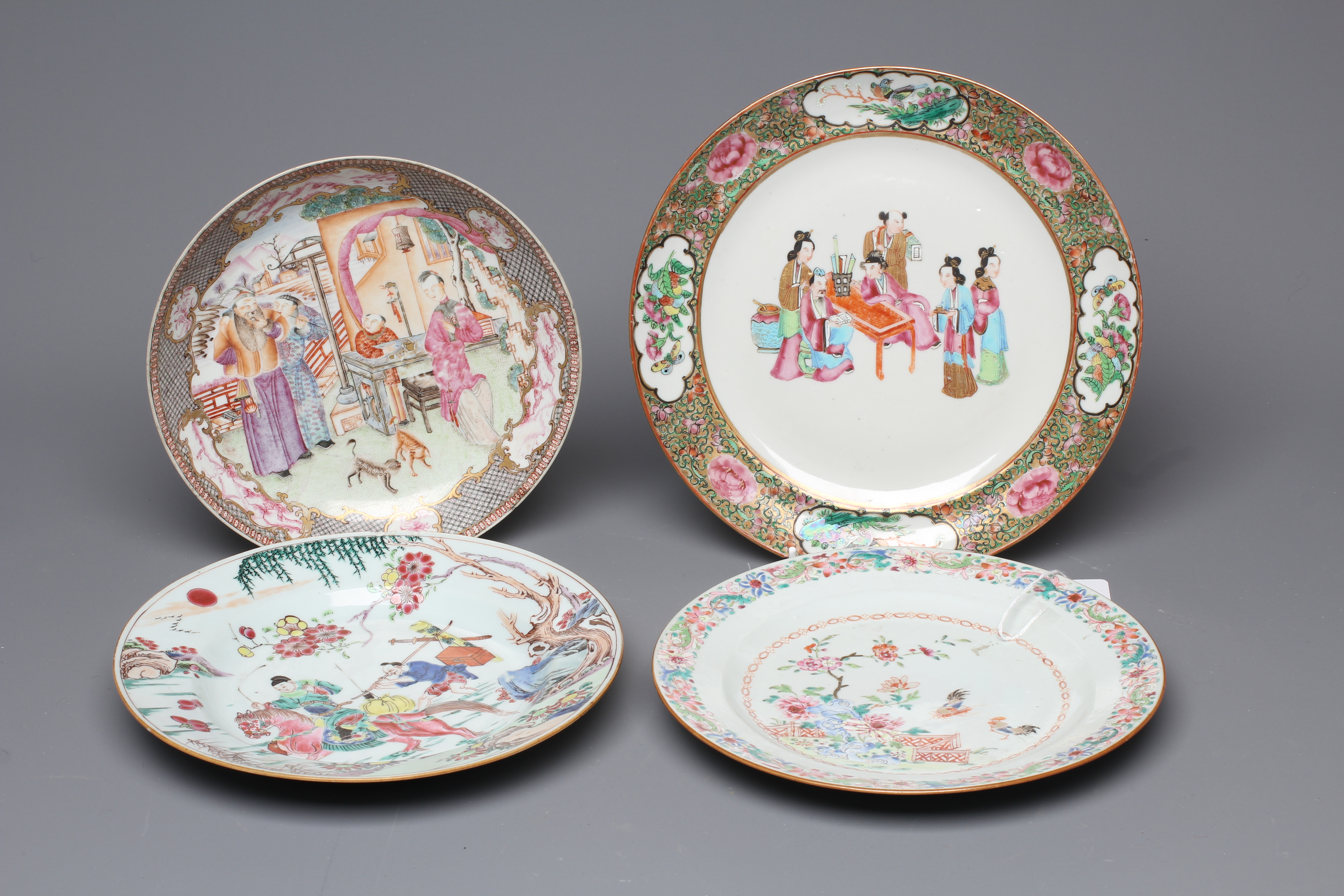 FOUR CHINESE FAMILLE ROSE PORCELAIN PLATES comprising a saucer dish with figures and dogs on a Image