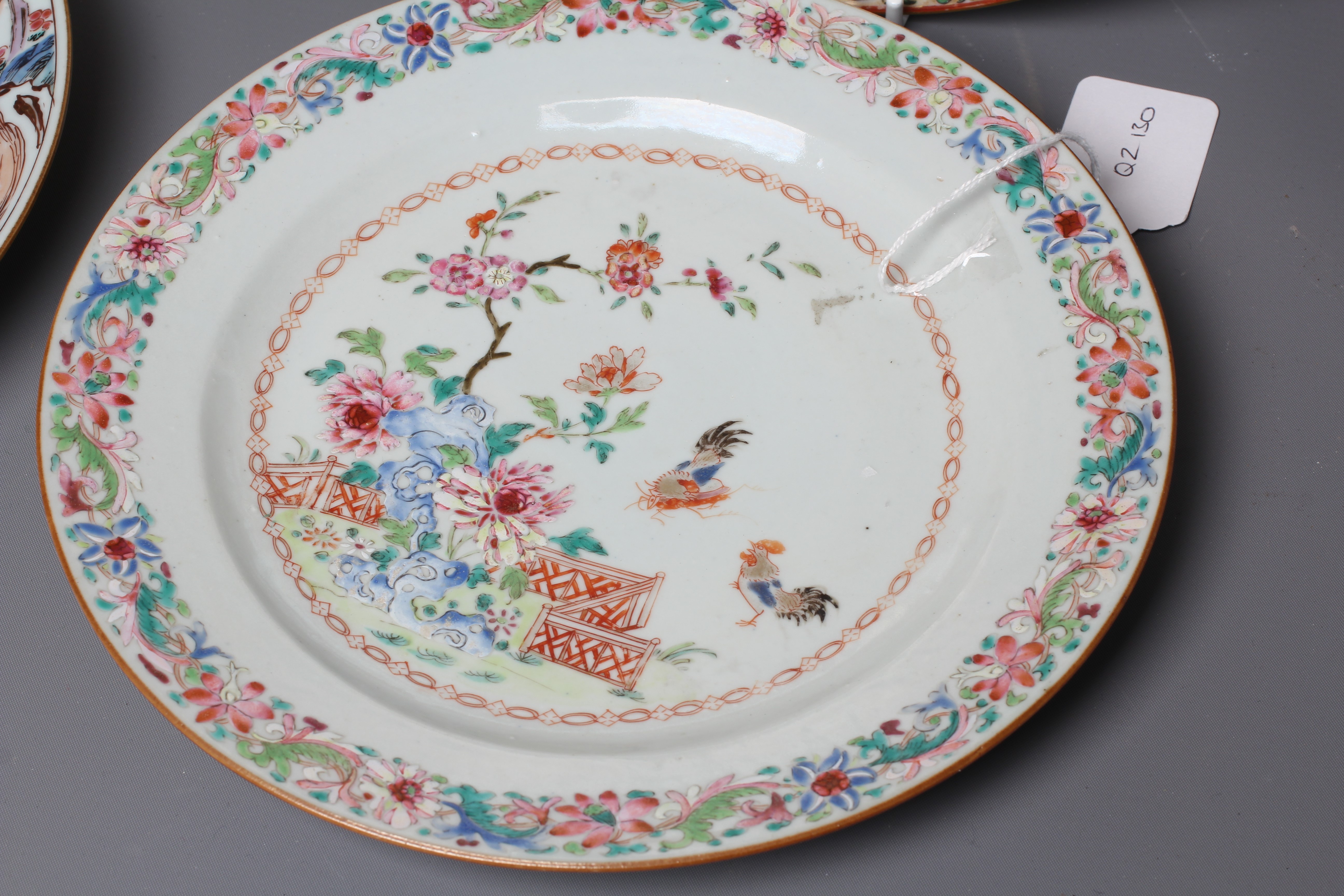 FOUR CHINESE FAMILLE ROSE PORCELAIN PLATES comprising a saucer dish with figures and dogs on a Image