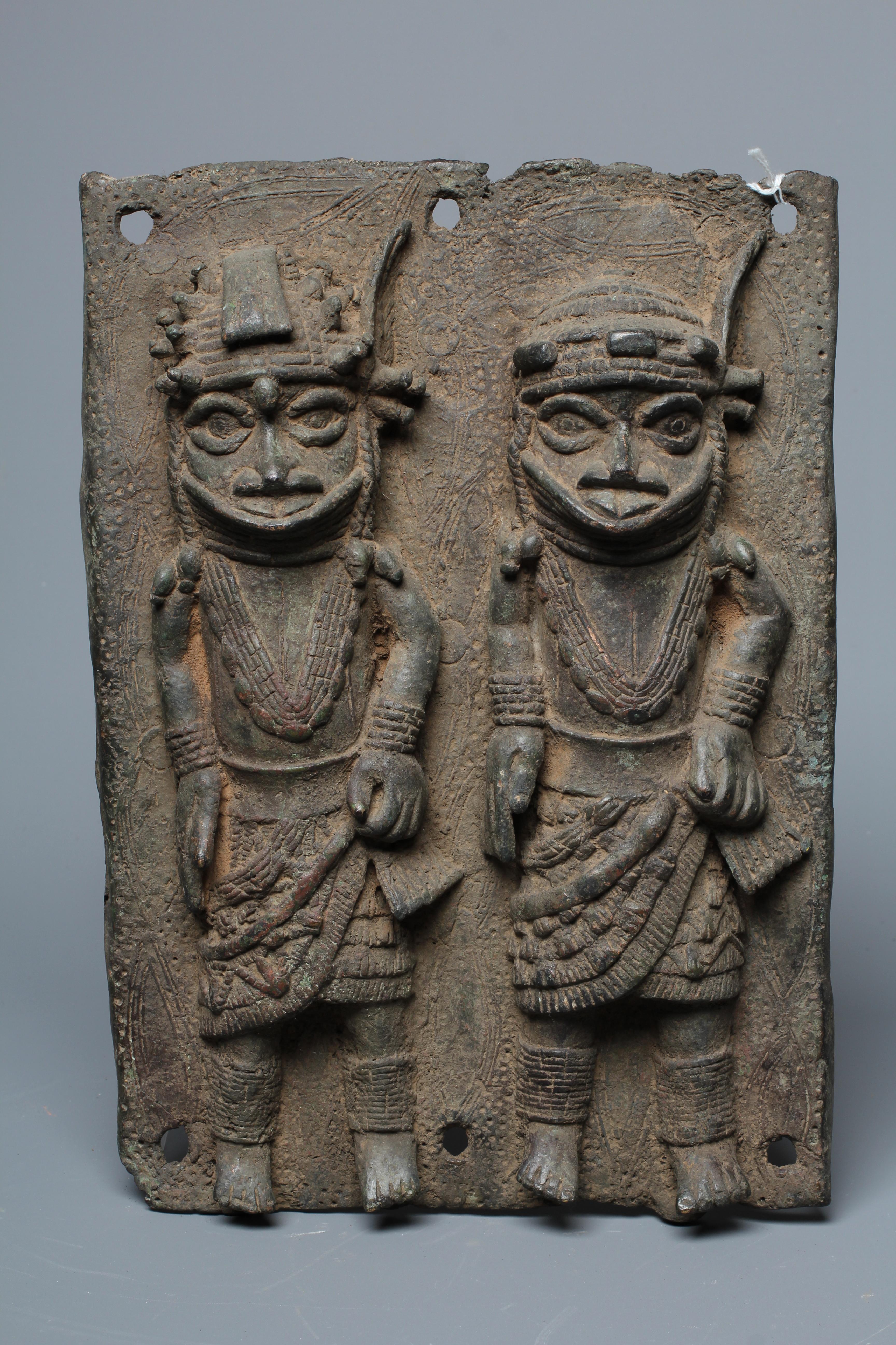 A BENIN BRONZE PLAQUE worked in relief with two standing warriors, 13" h x 9" w Image