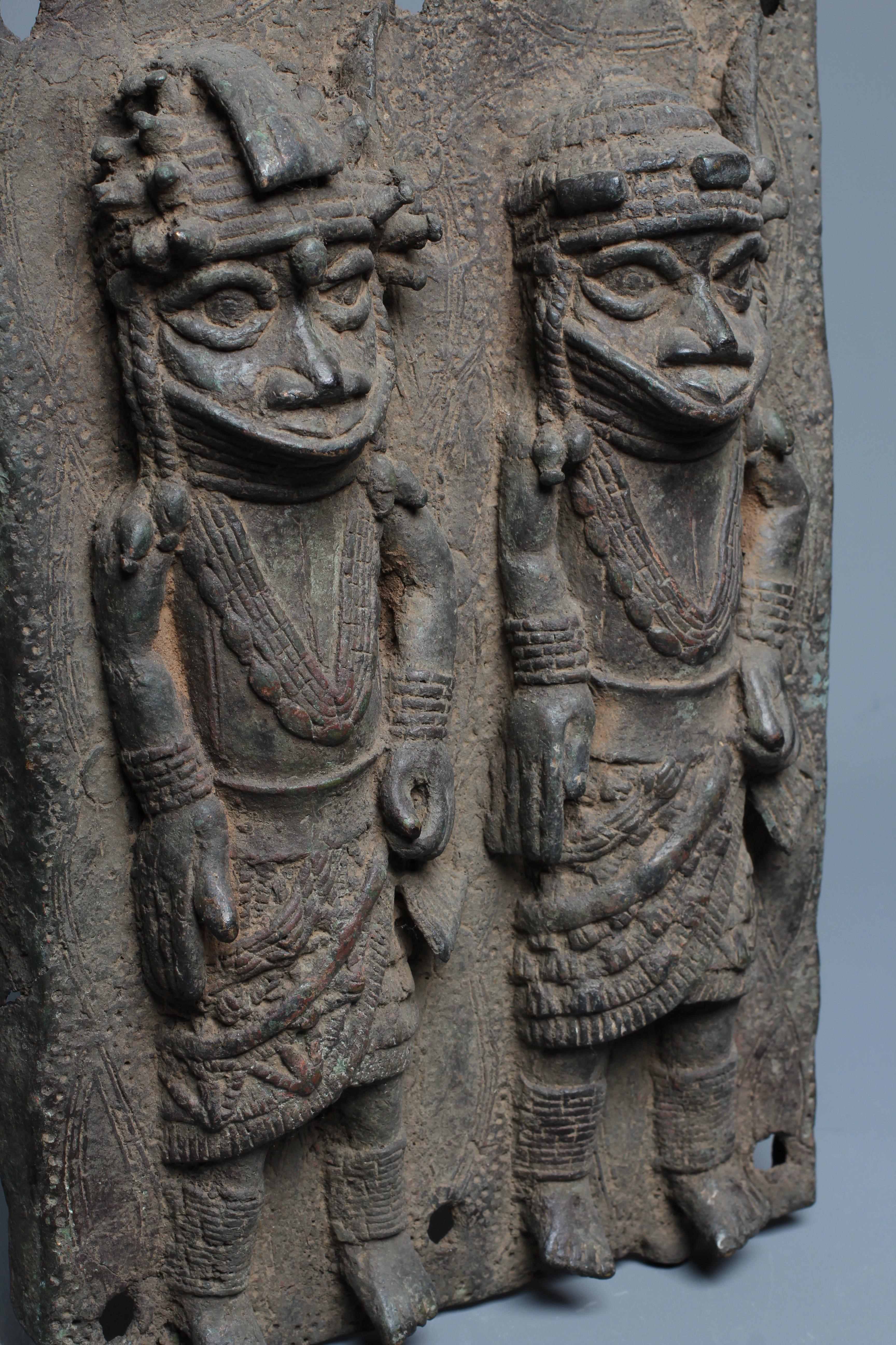 A BENIN BRONZE PLAQUE worked in relief with two standing warriors, 13" h x 9" w Image