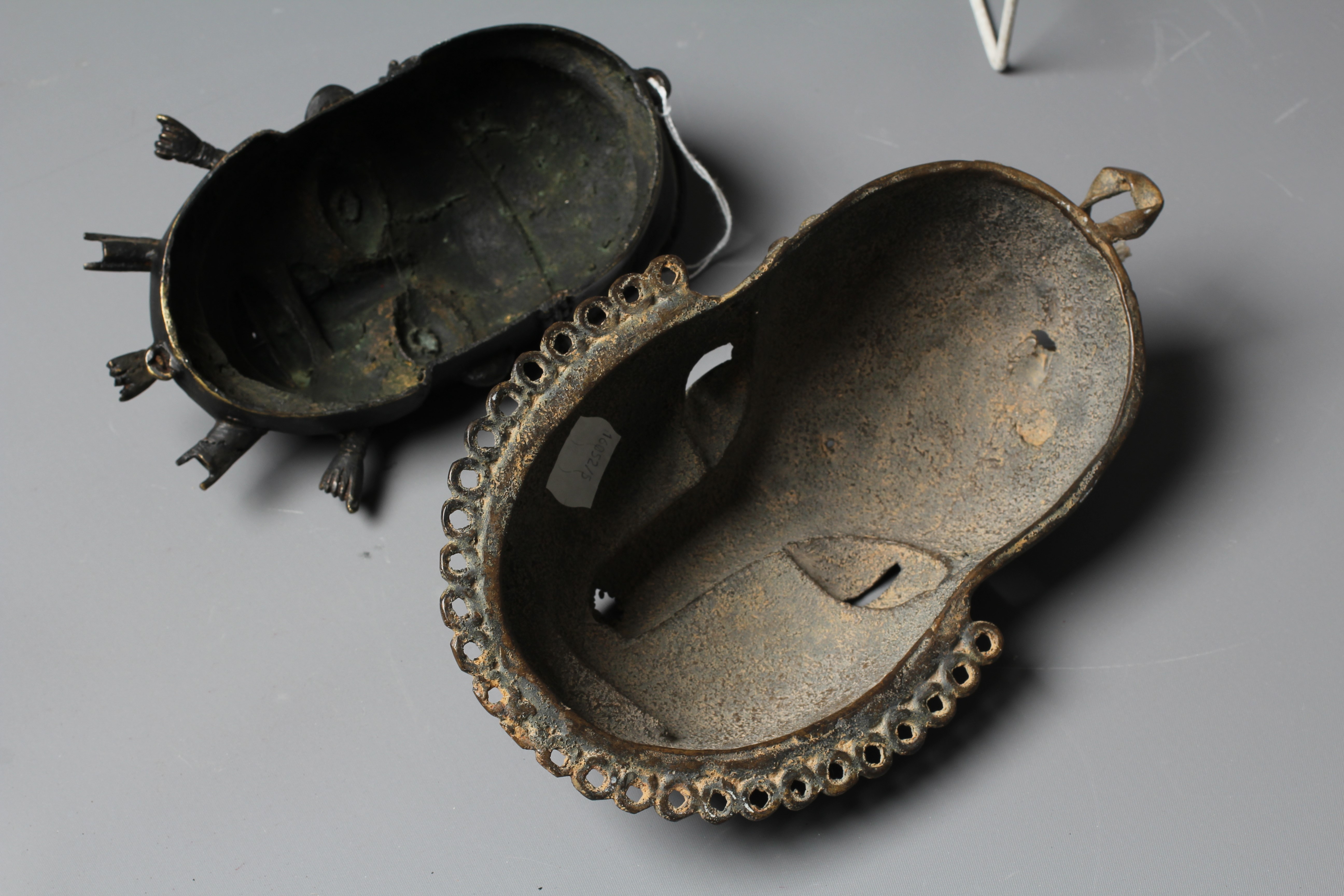 A BENIN CAST BRASS PENDANT MASK with tooled decoration, 8" high, together with a second Benin brass Image