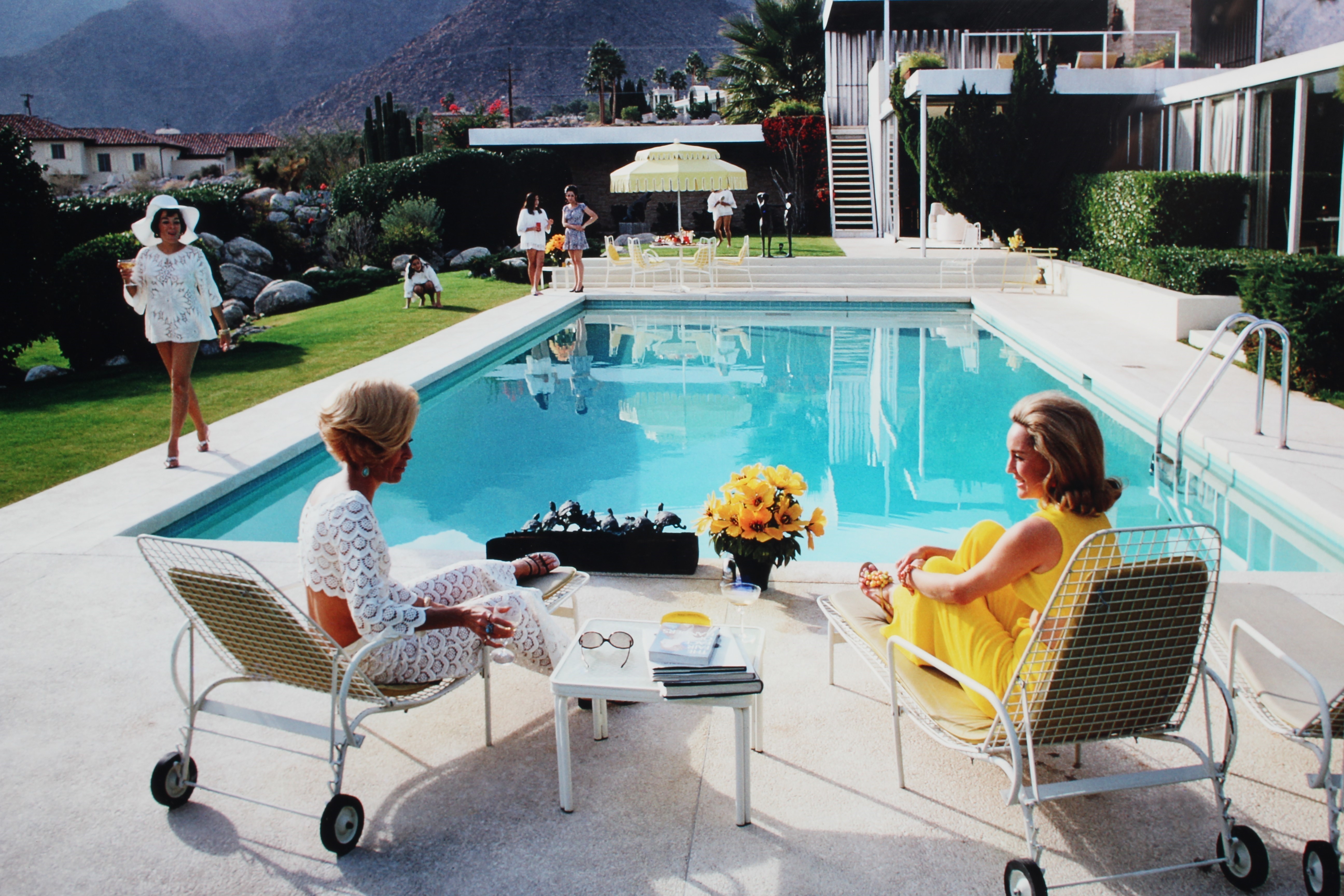 AFTER SLIM AARONS (1916-2000) Poolside Gossip (1970), photographic print, 26" x 38 1/2" (SH), framed Image