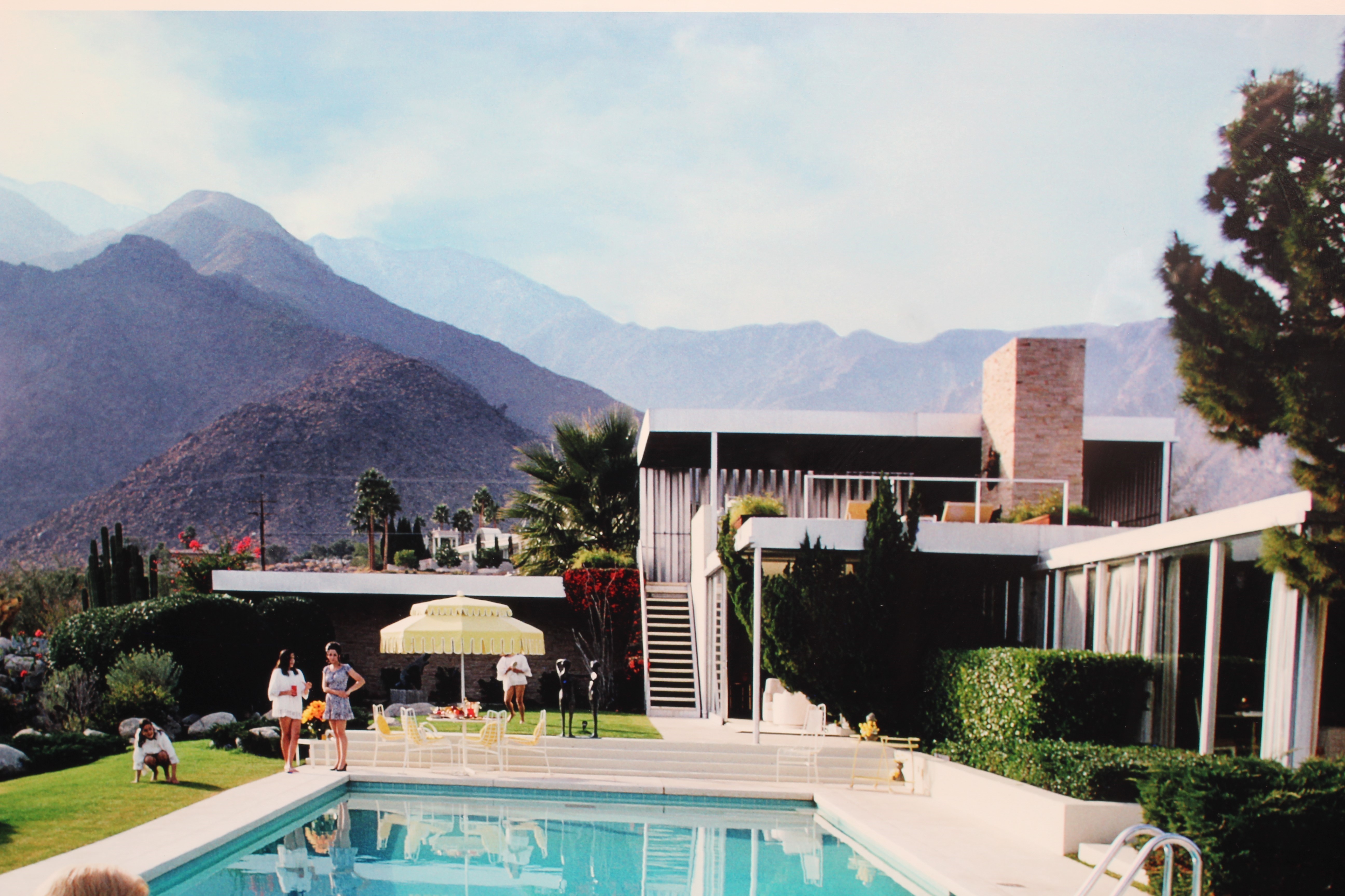 AFTER SLIM AARONS (1916-2000) Poolside Gossip (1970), photographic print, 26" x 38 1/2" (SH), framed Image