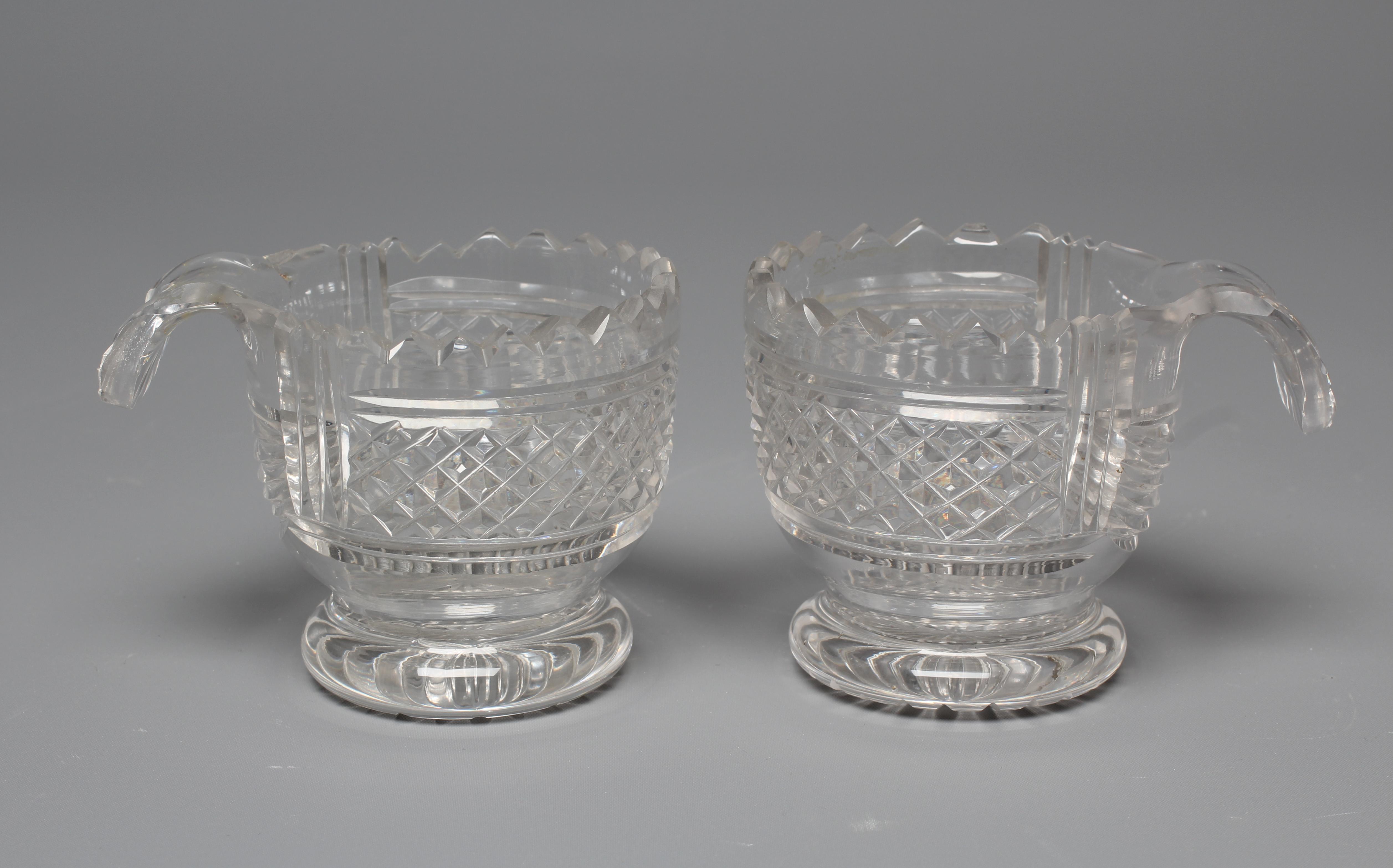 A PAIR OF IRISH GLASS PIGGINS, early 19th century, the plain U bowls with dentil cut rims and Image