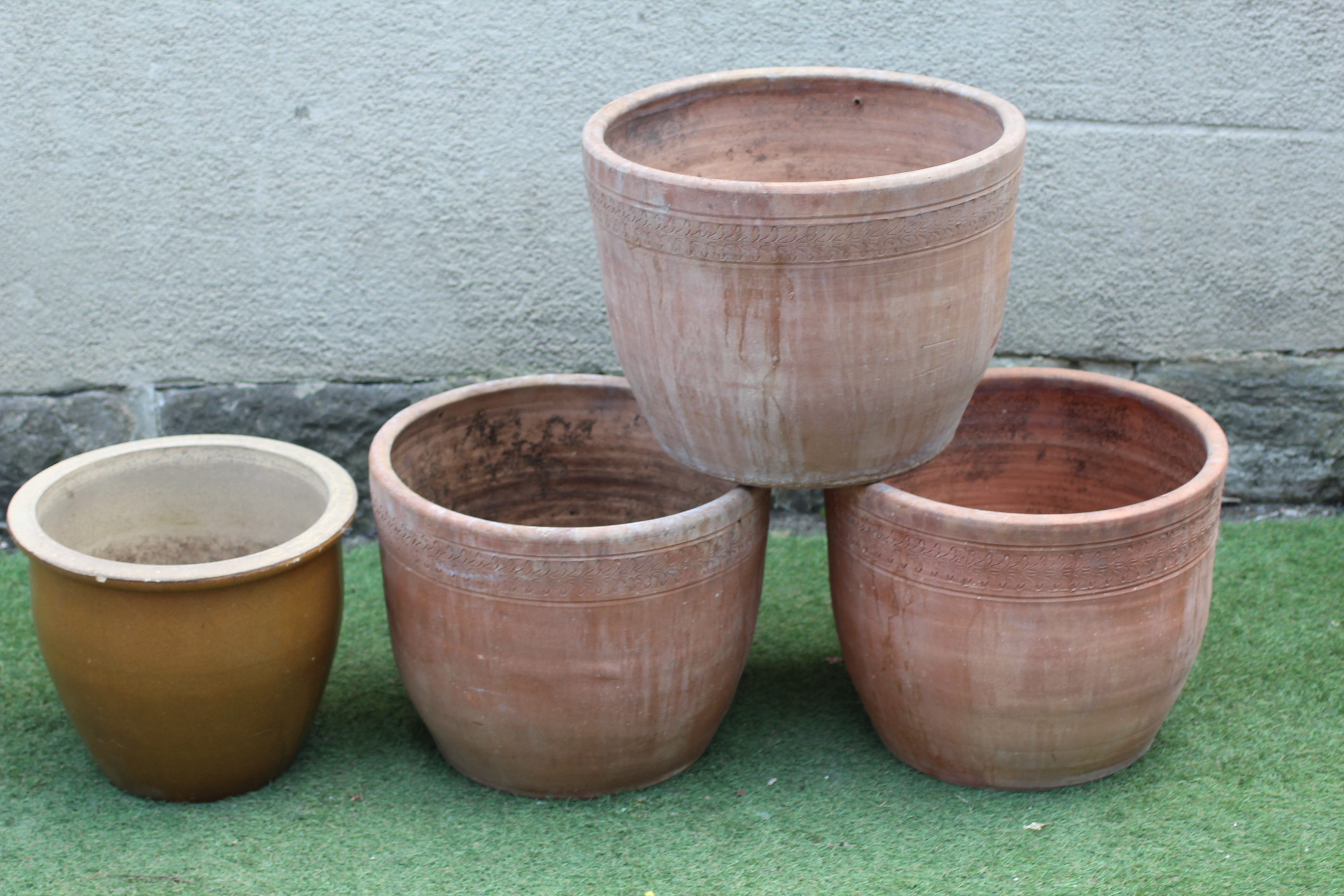 A SET OF THREE TERRACOTTA PLANT POTS, modern, of tapering form with leaf banded rim, inscribed Image