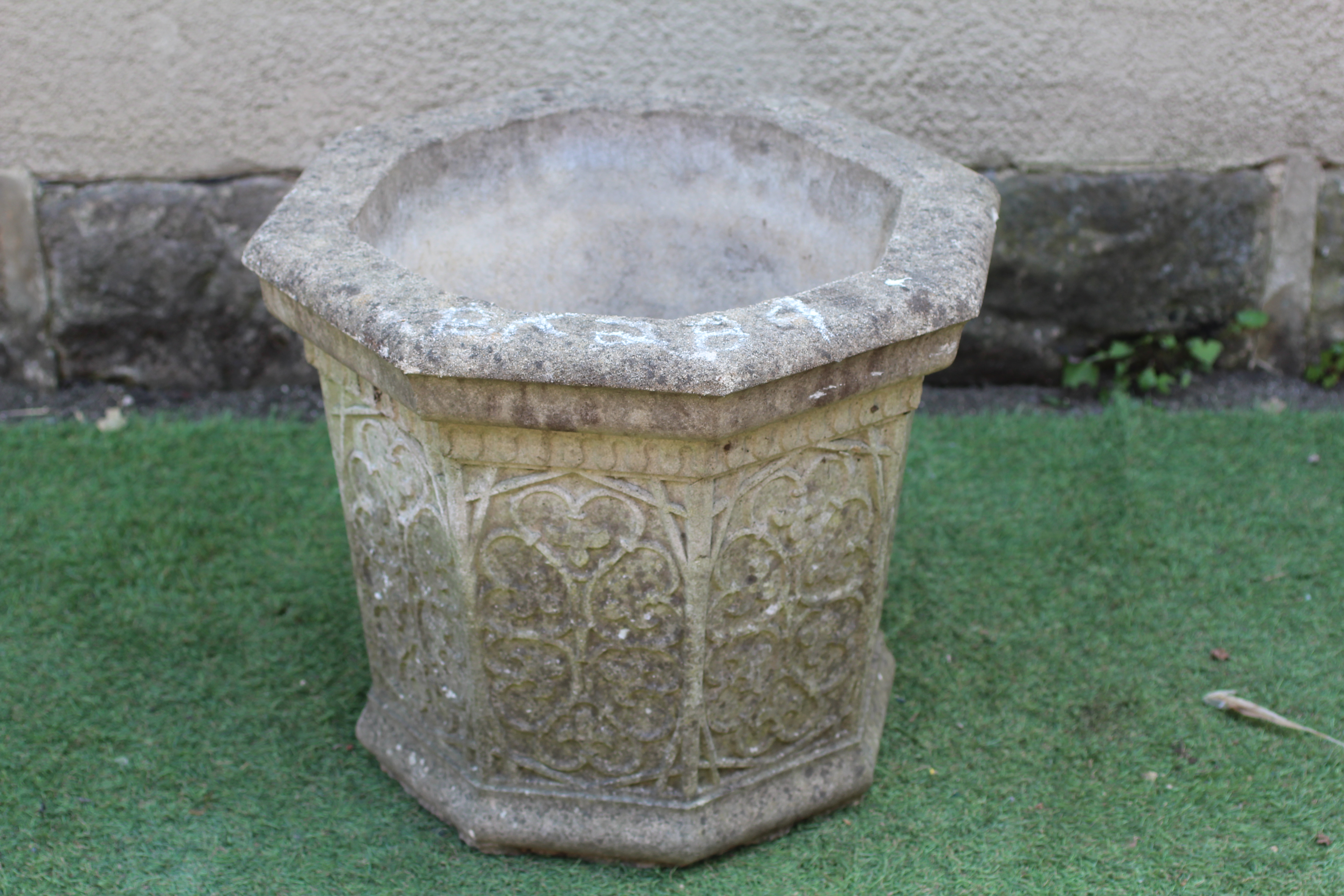 A CAST STONE PLANTER, modern, of tapering panelled form with moulded rim, the sides with foliate Image