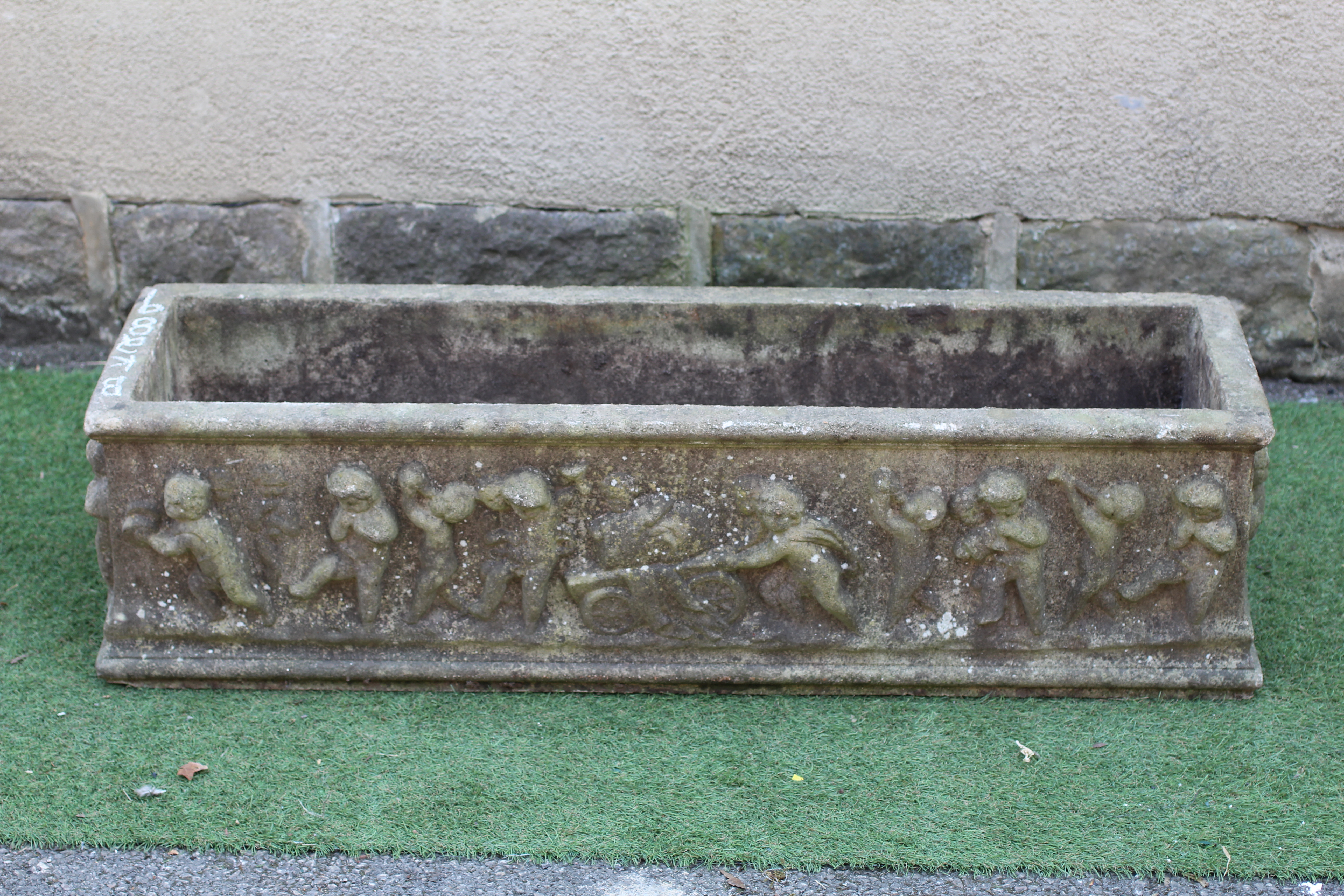 A LARGE CAST STONE OBLONG PLANTER, modern, with a frieze of Bacchanalian putti in high relief, 46" w Image