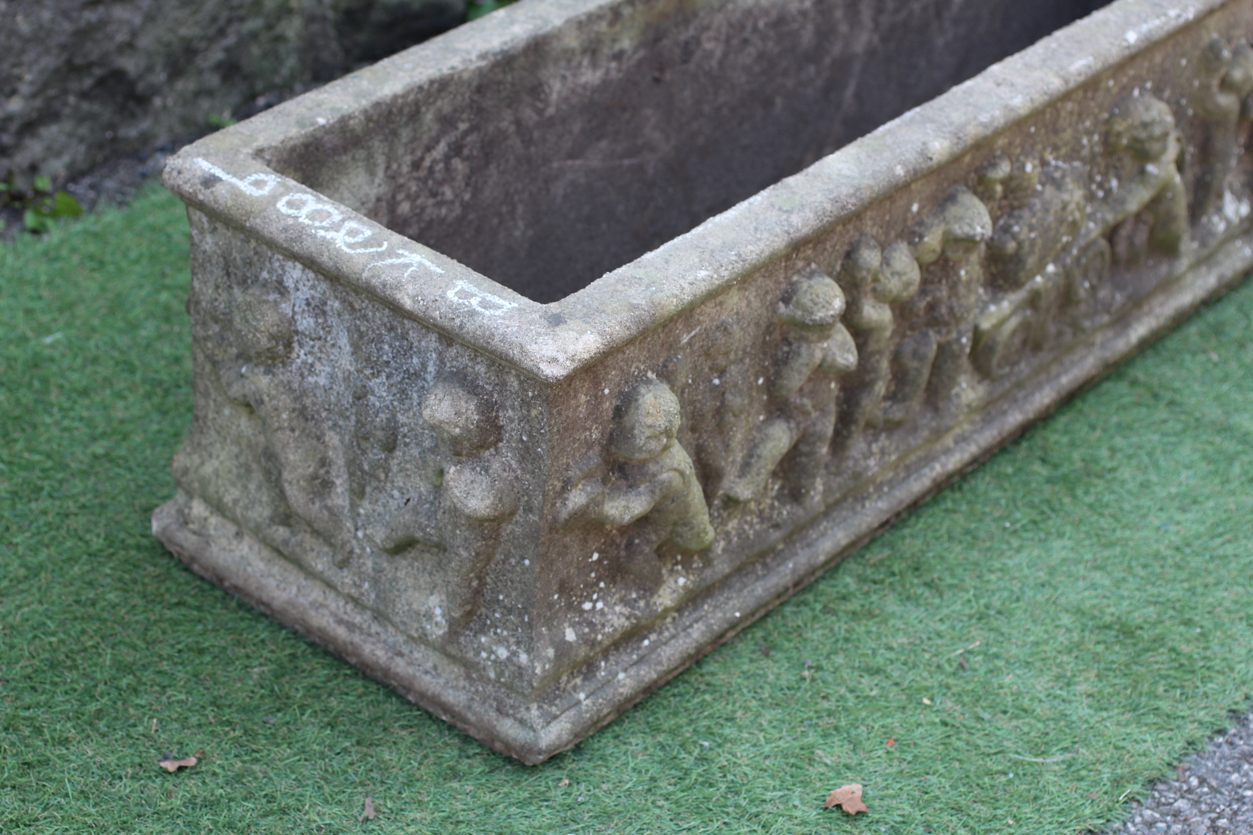 A LARGE CAST STONE OBLONG PLANTER, modern, with a frieze of Bacchanalian putti in high relief, 46" w Image
