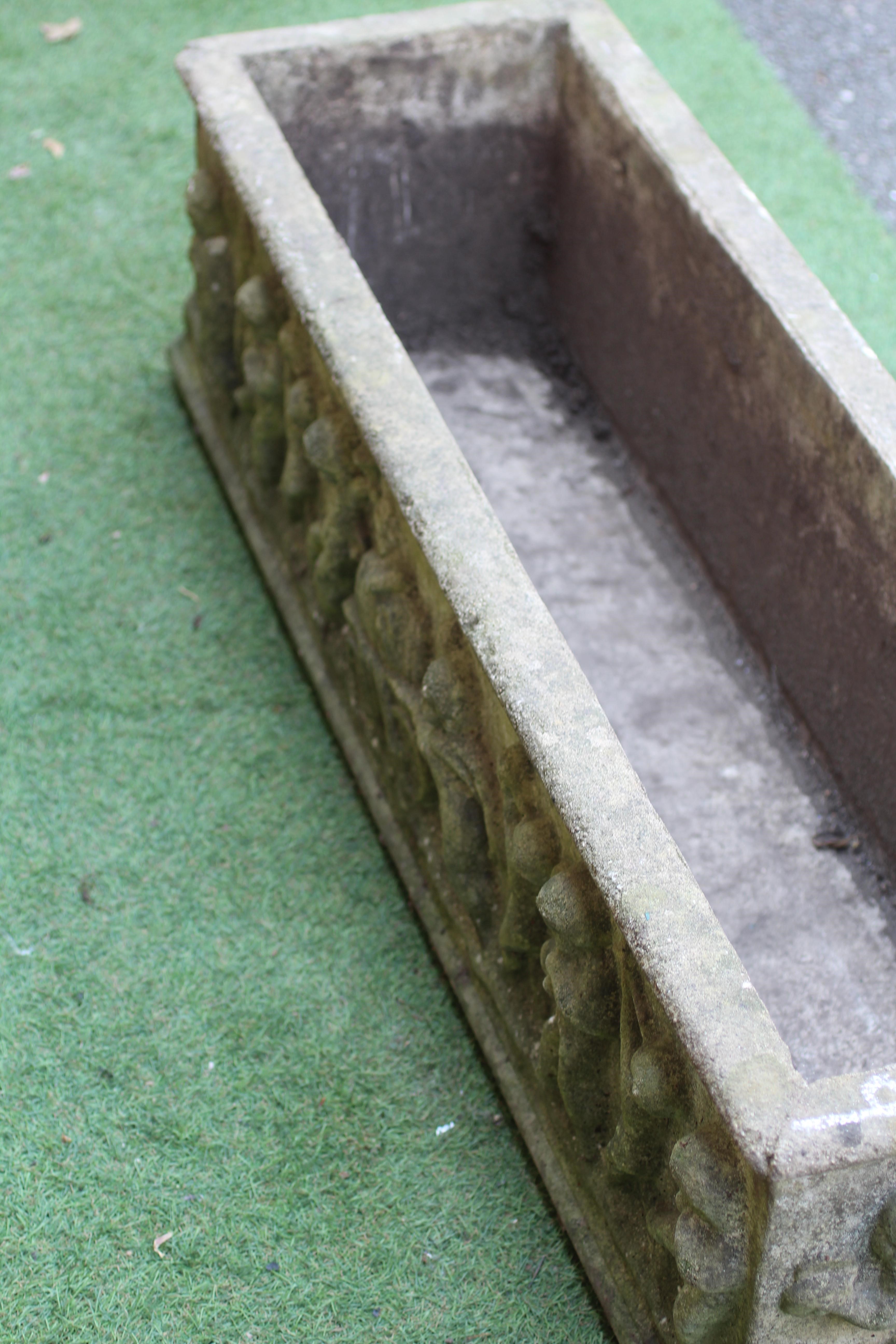 A LARGE CAST STONE OBLONG PLANTER, modern, with a frieze of Bacchanalian putti in high relief, 46" w Image