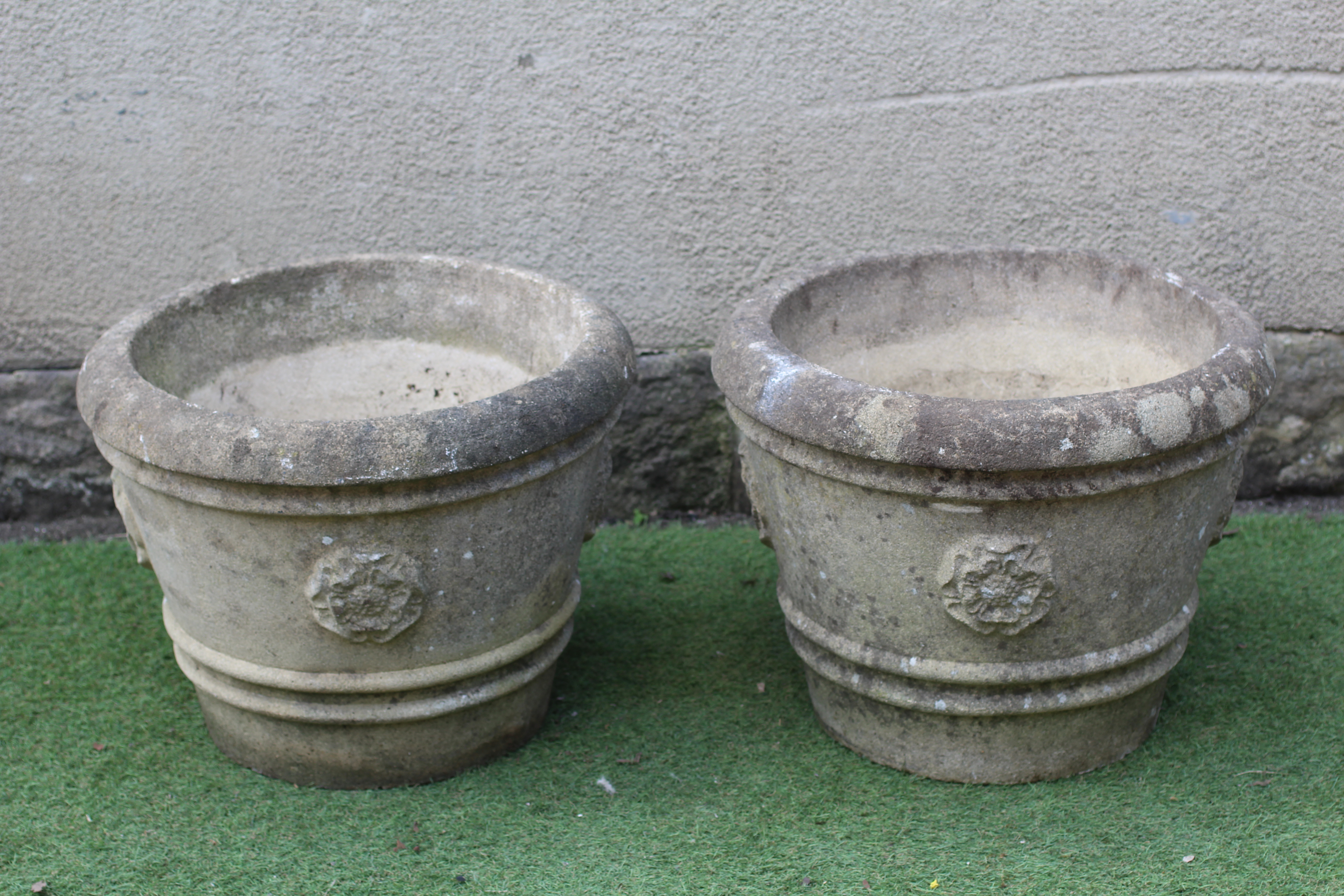 A PAIR OF CAST STONE URNS, modern, the ribbed tapering sides with Yorkshire roses in relief, 22 1/2" Image