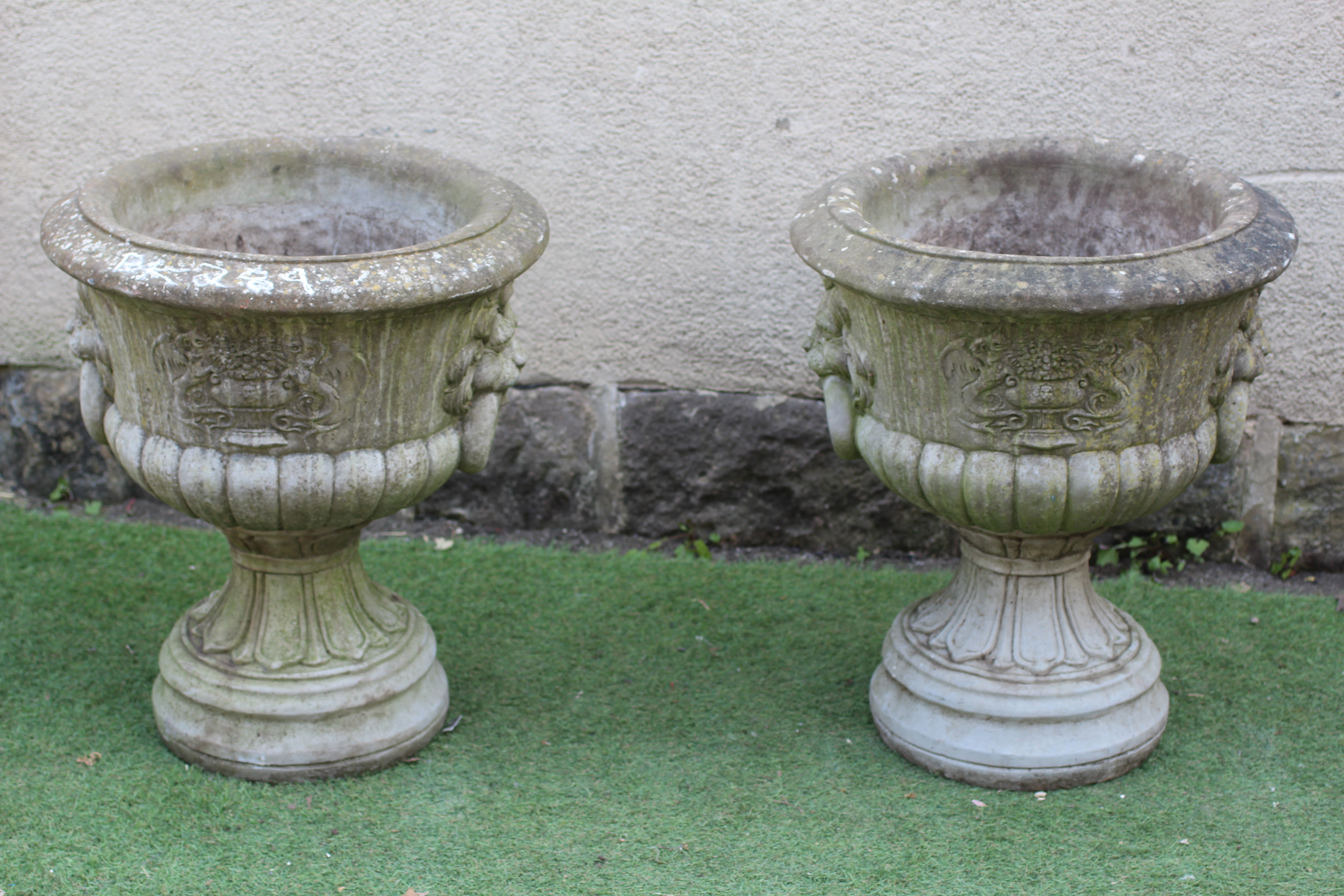A PAIR OF CAST STONE URNS, modern, of half fluted tapering form with lion mask ring handles, the Image