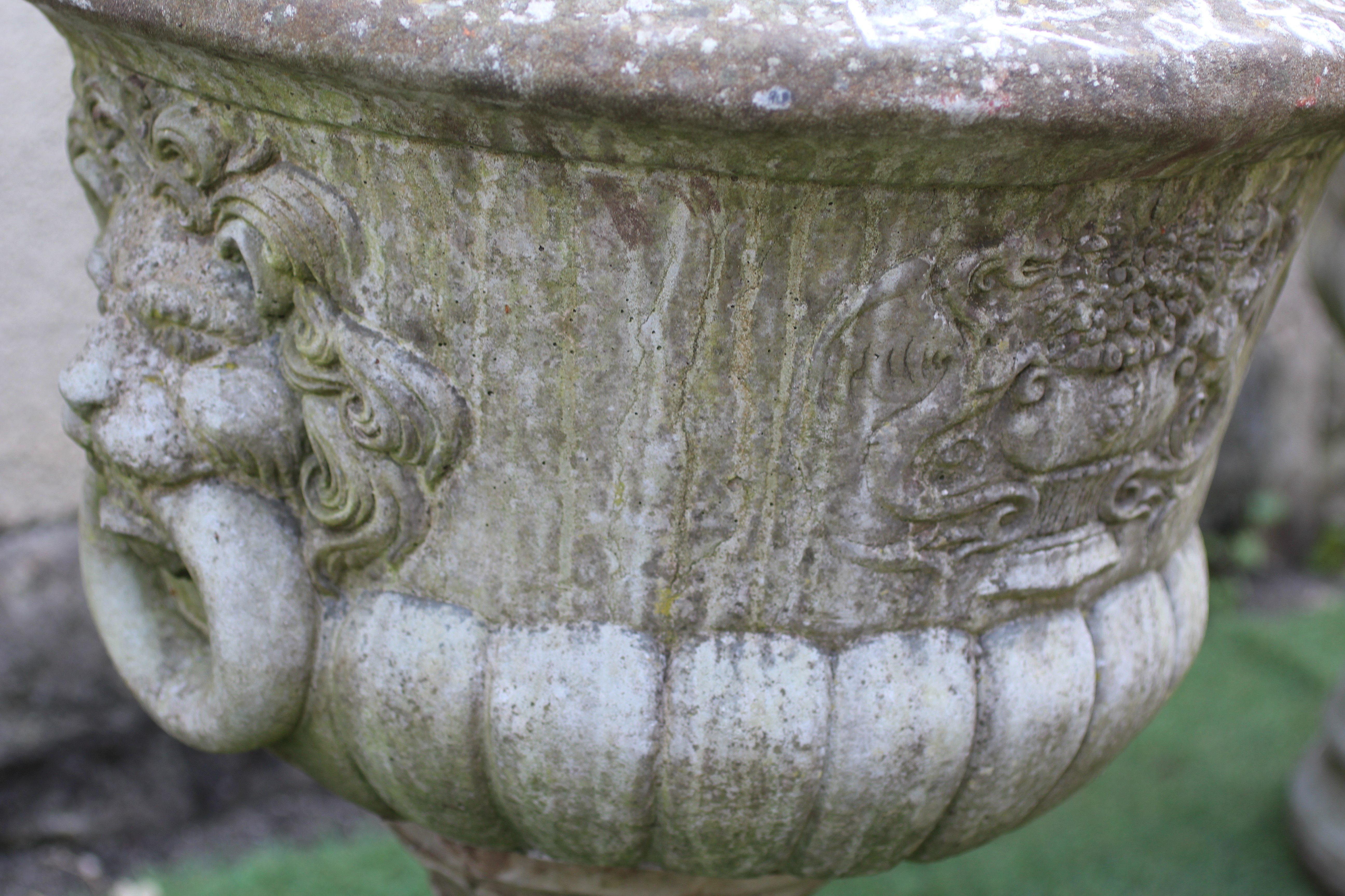 A PAIR OF CAST STONE URNS, modern, of half fluted tapering form with lion mask ring handles, the Image