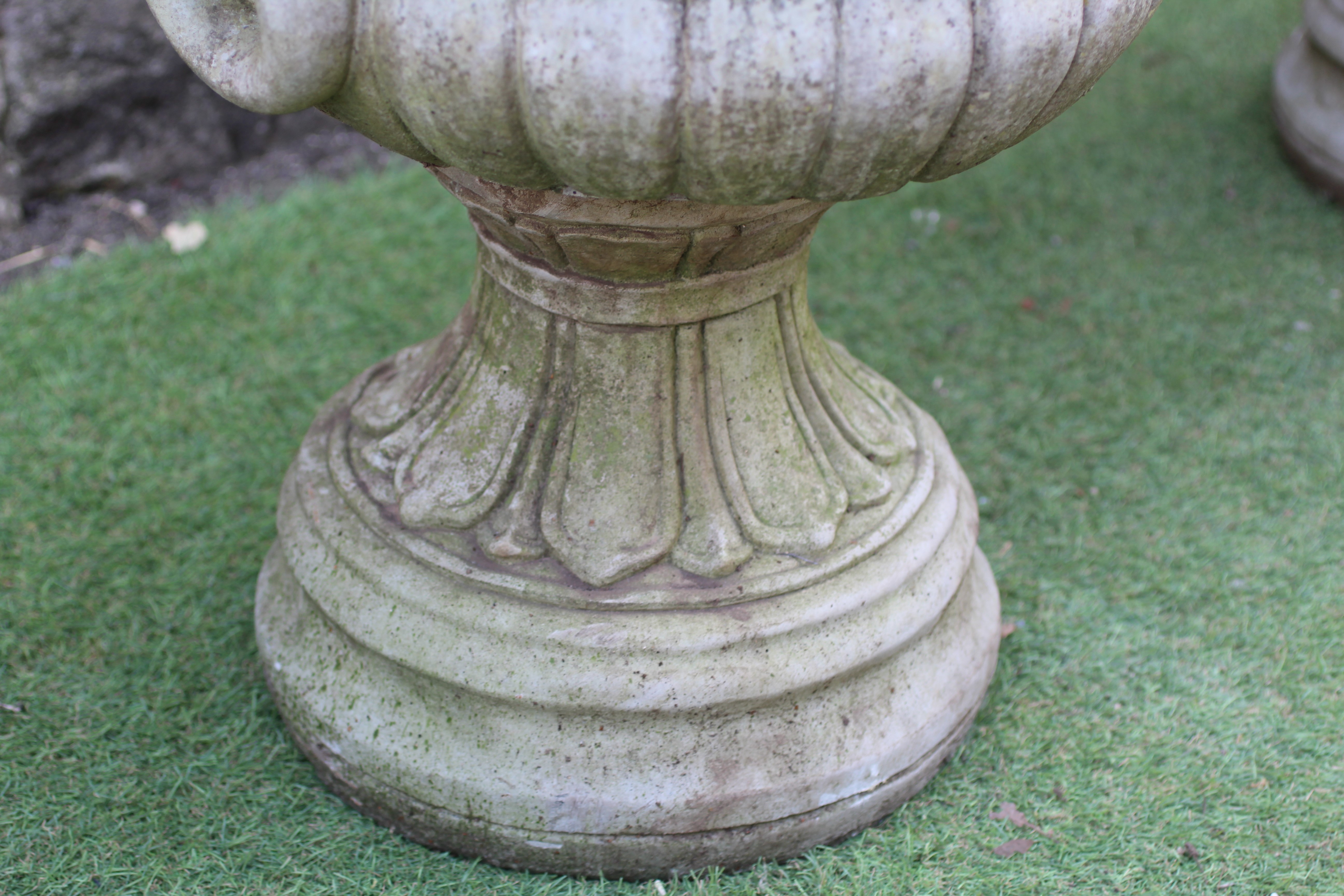 A PAIR OF CAST STONE URNS, modern, of half fluted tapering form with lion mask ring handles, the Image