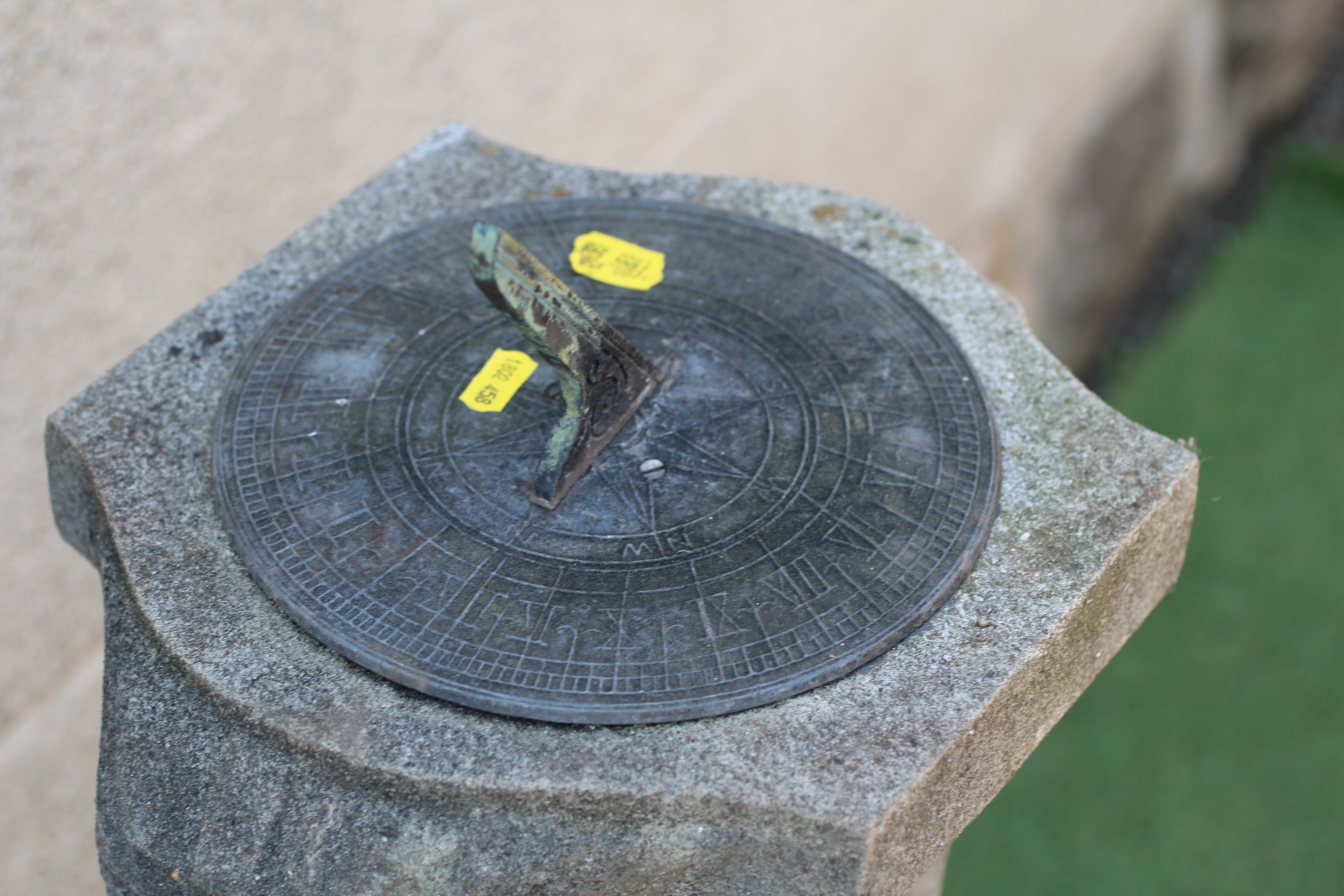 A CAST STONE SUNDIAL, the metal gnomon raised on square tapering column with bearded male mask to Image