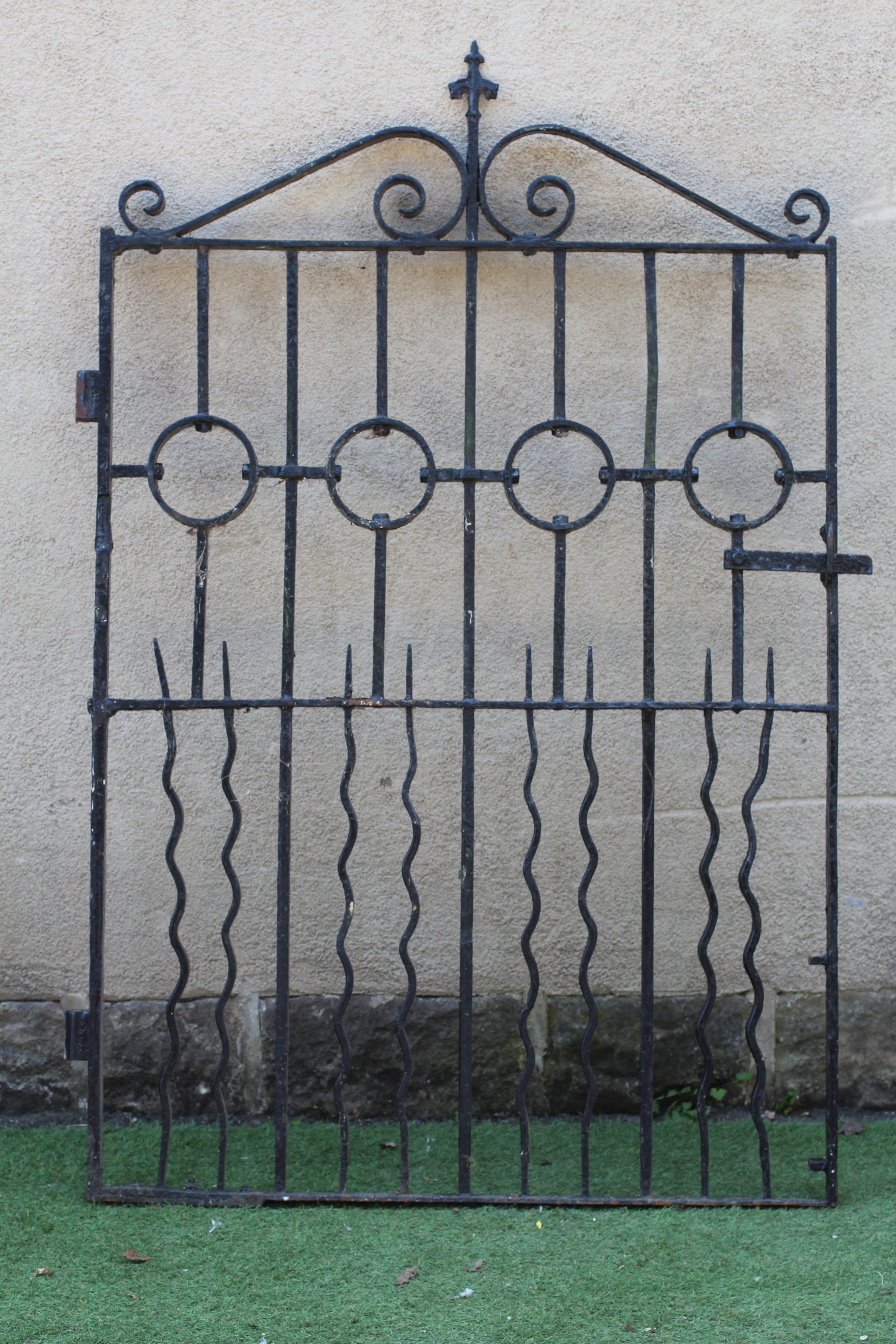 A WROUGHT AND CAST IRON PEDESTRIAN GATE, 20th century, the arched scrolled top with fleur de lys Image