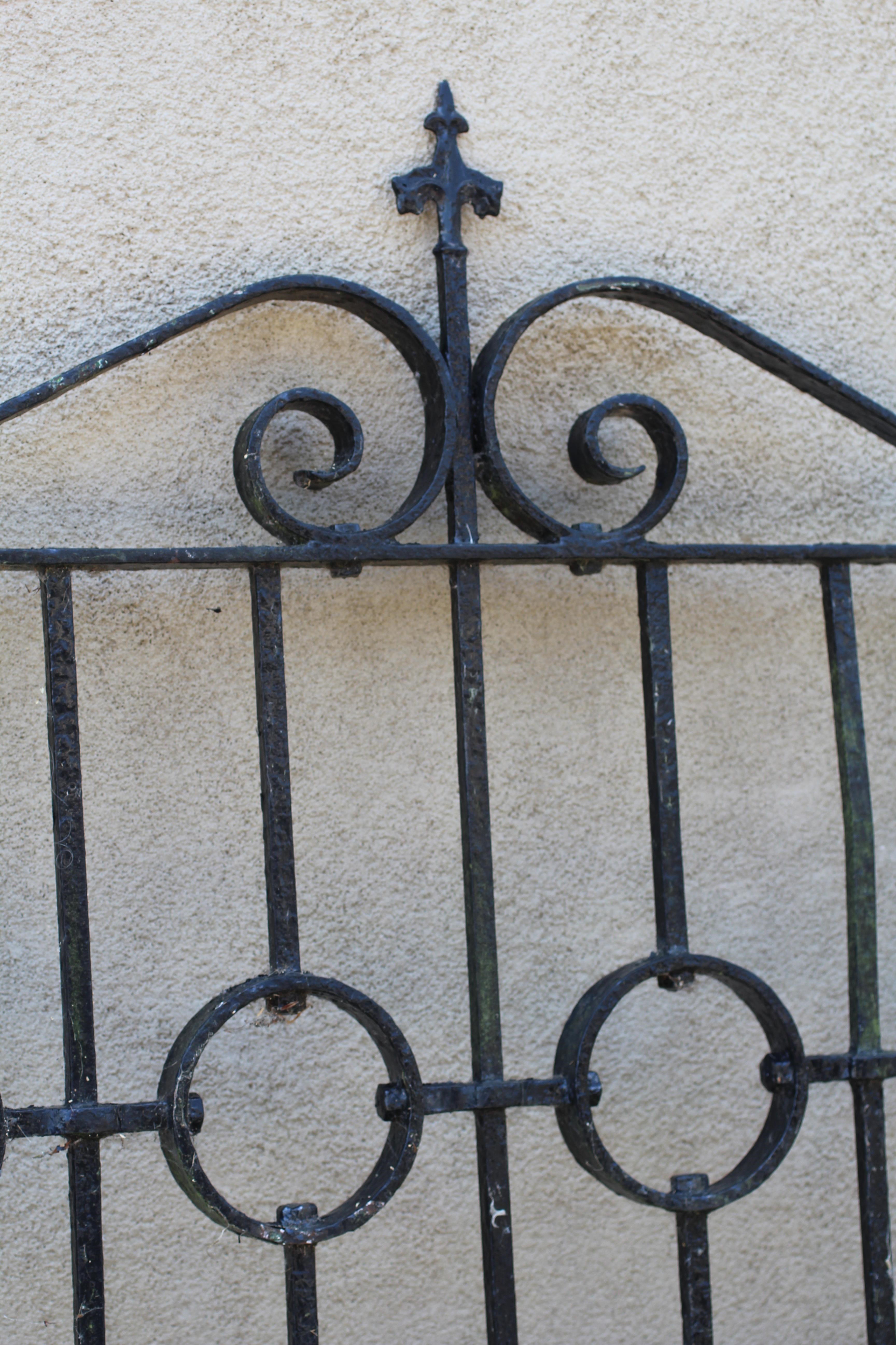 A WROUGHT AND CAST IRON PEDESTRIAN GATE, 20th century, the arched scrolled top with fleur de lys Image