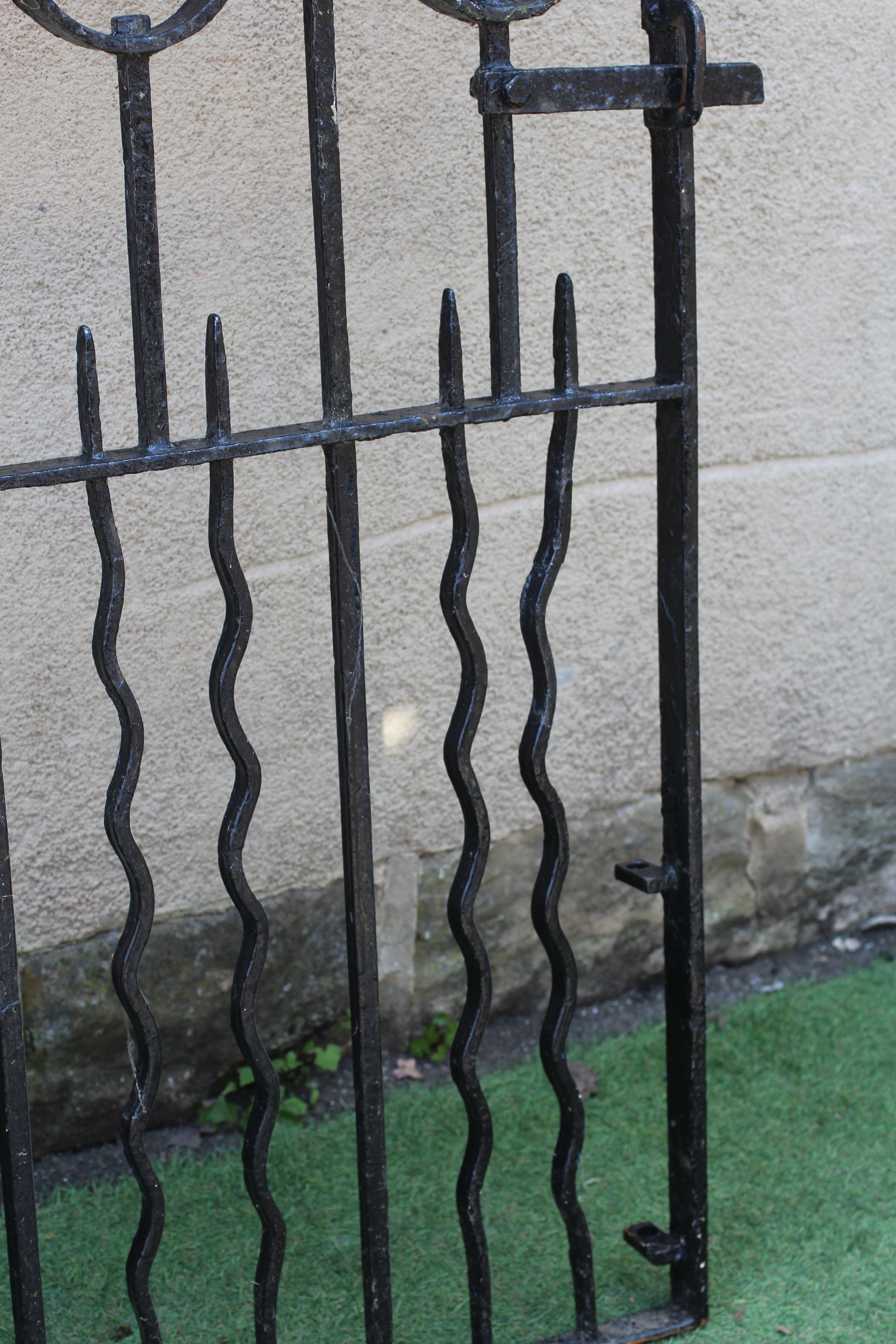 A WROUGHT AND CAST IRON PEDESTRIAN GATE, 20th century, the arched scrolled top with fleur de lys Image