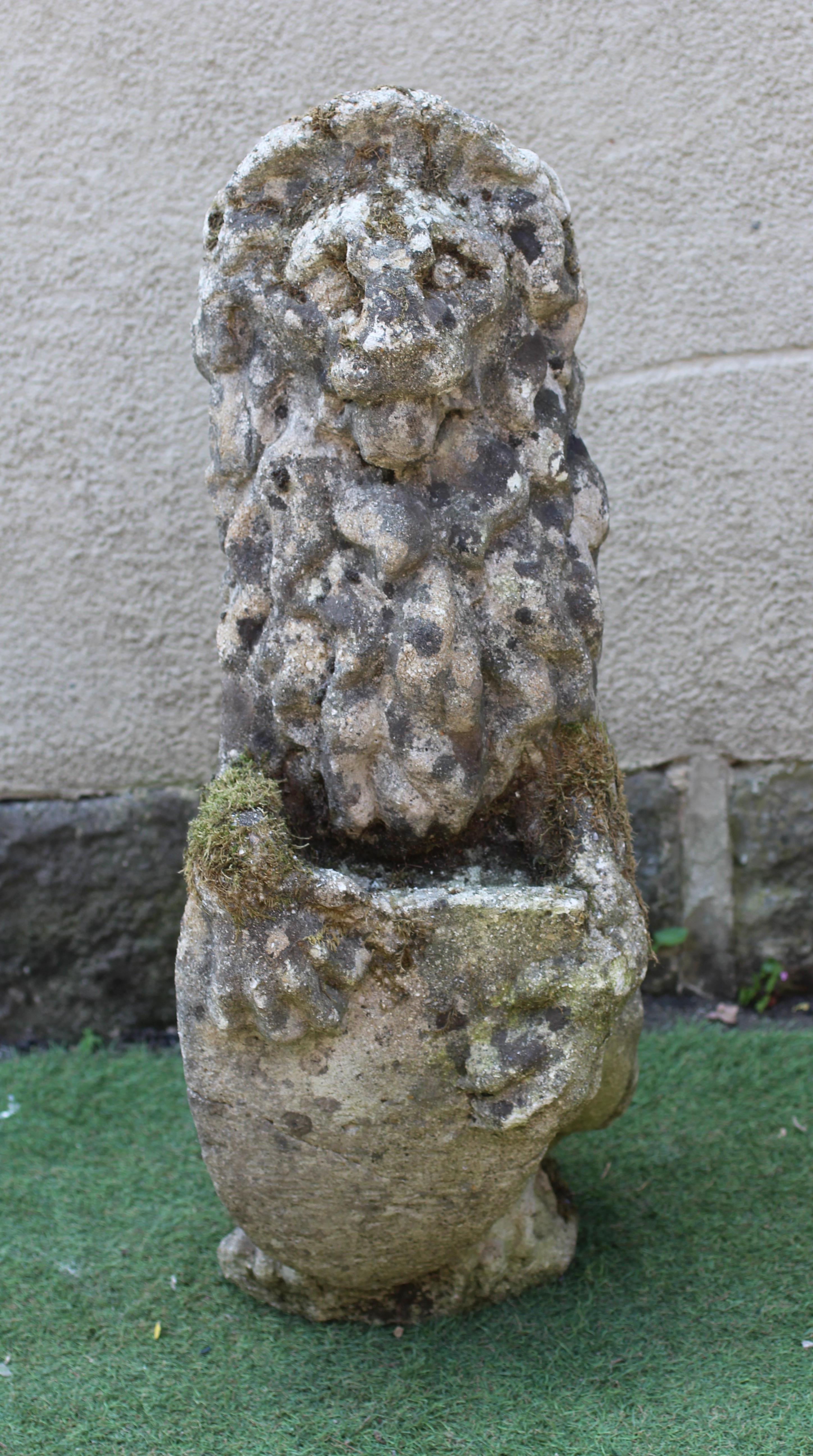 A CAST STONE LION, modern, modelled sejant with a paw resting on a shield, 11 1/2" w x 34" h Image