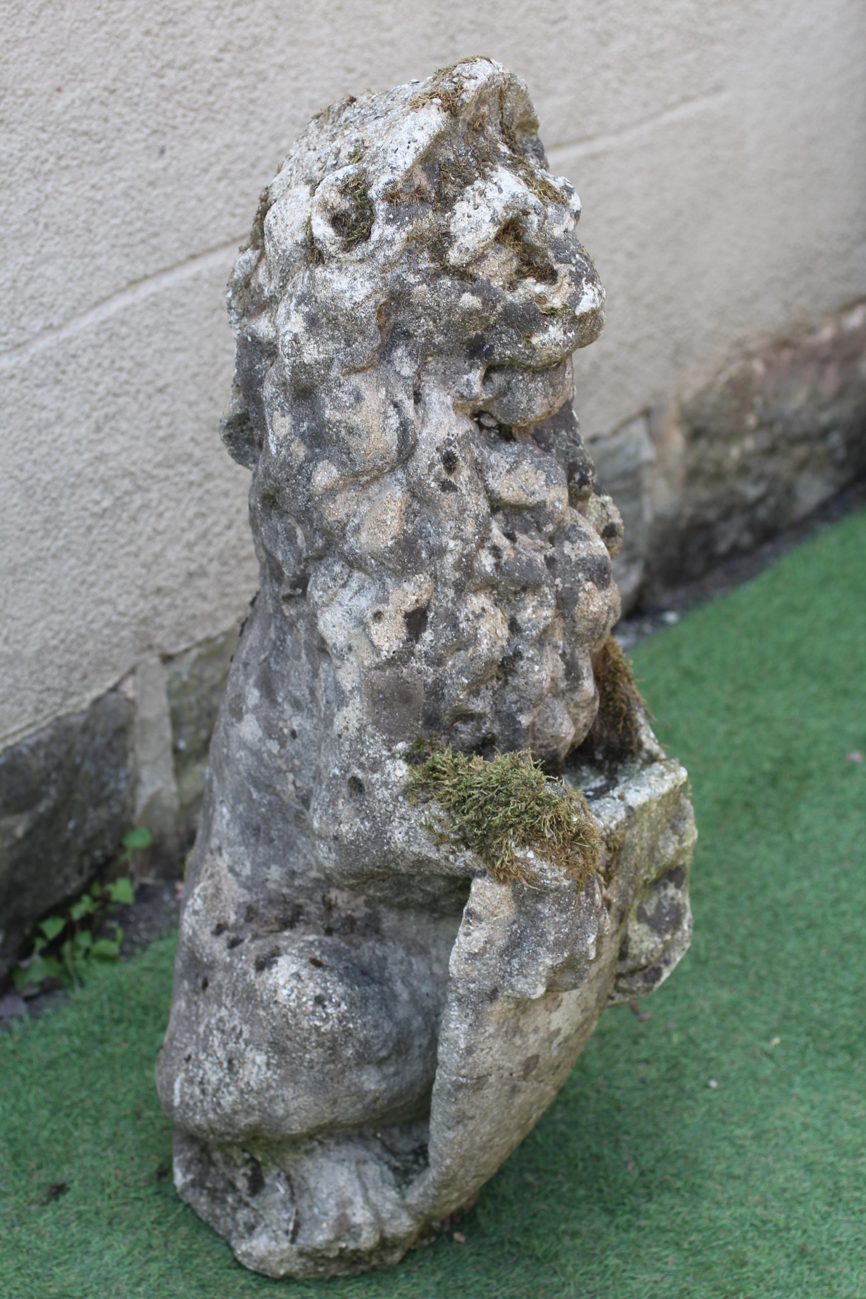 A CAST STONE LION, modern, modelled sejant with a paw resting on a shield, 11 1/2" w x 34" h Image