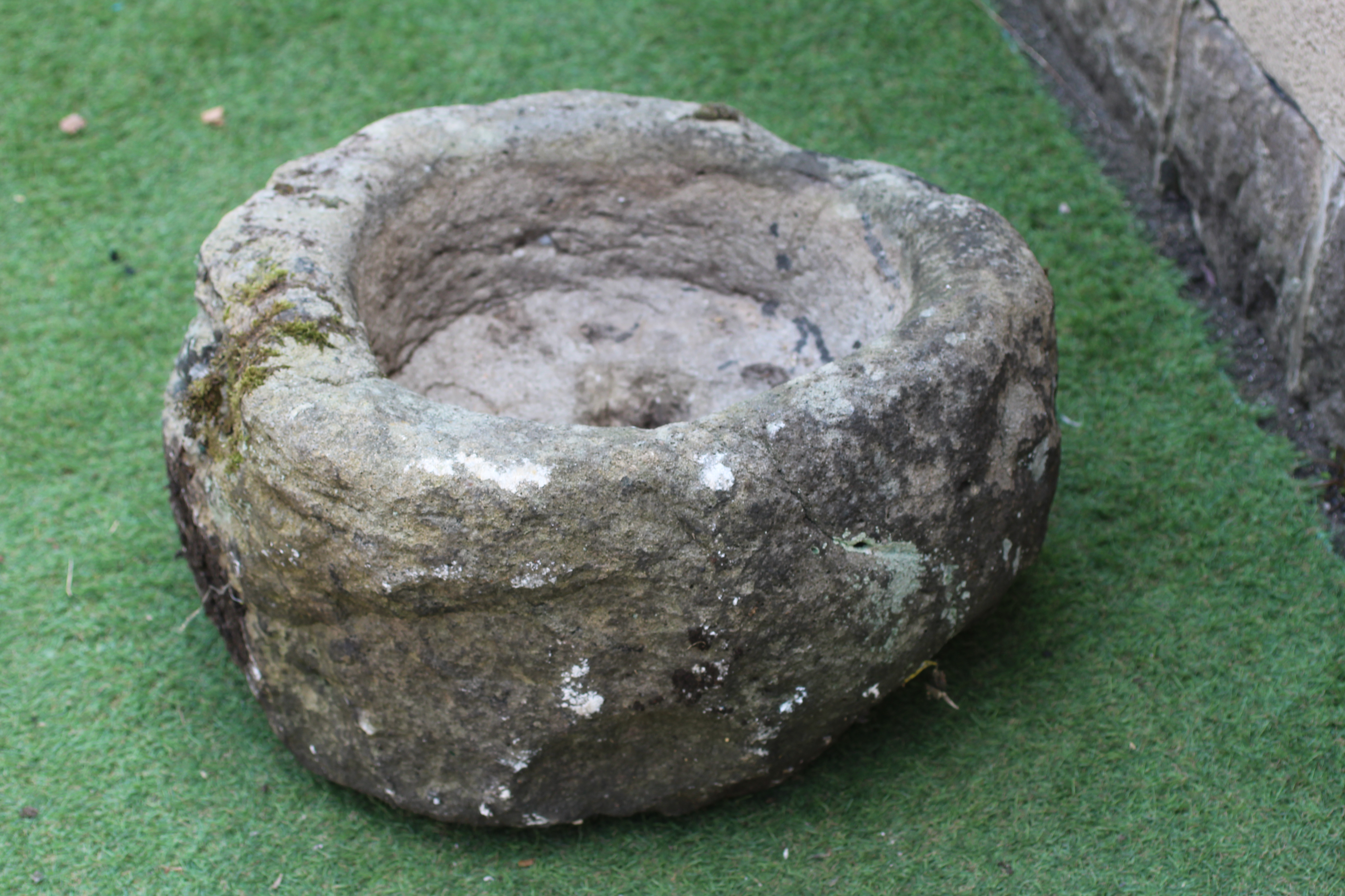 A SANDSTONE TROUGH of rough hewn circular form, 22 1/2" w x 11 1/2" h Image