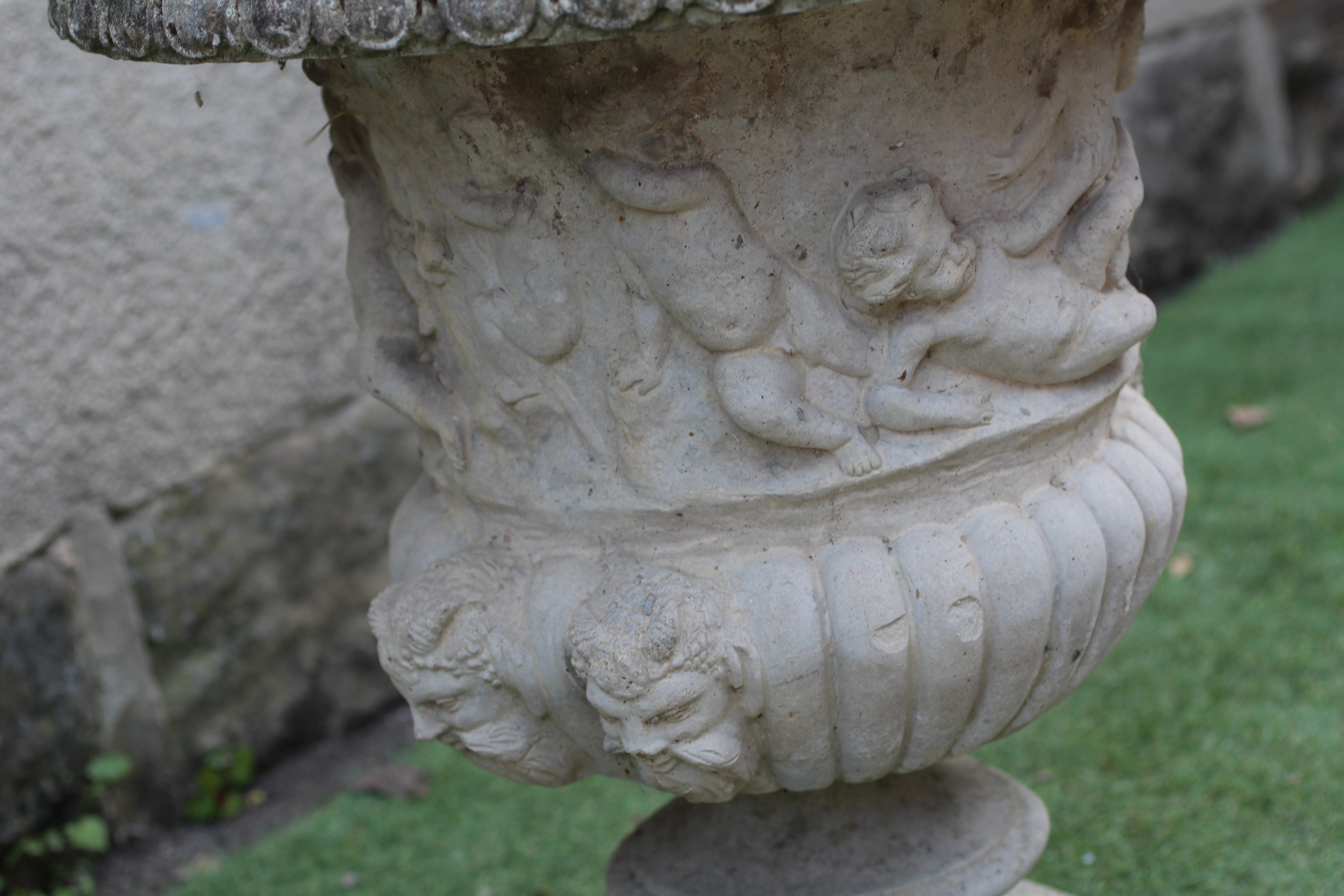 A CAST STONE URN of half fluted campana form with egg and dart moulded rim Image