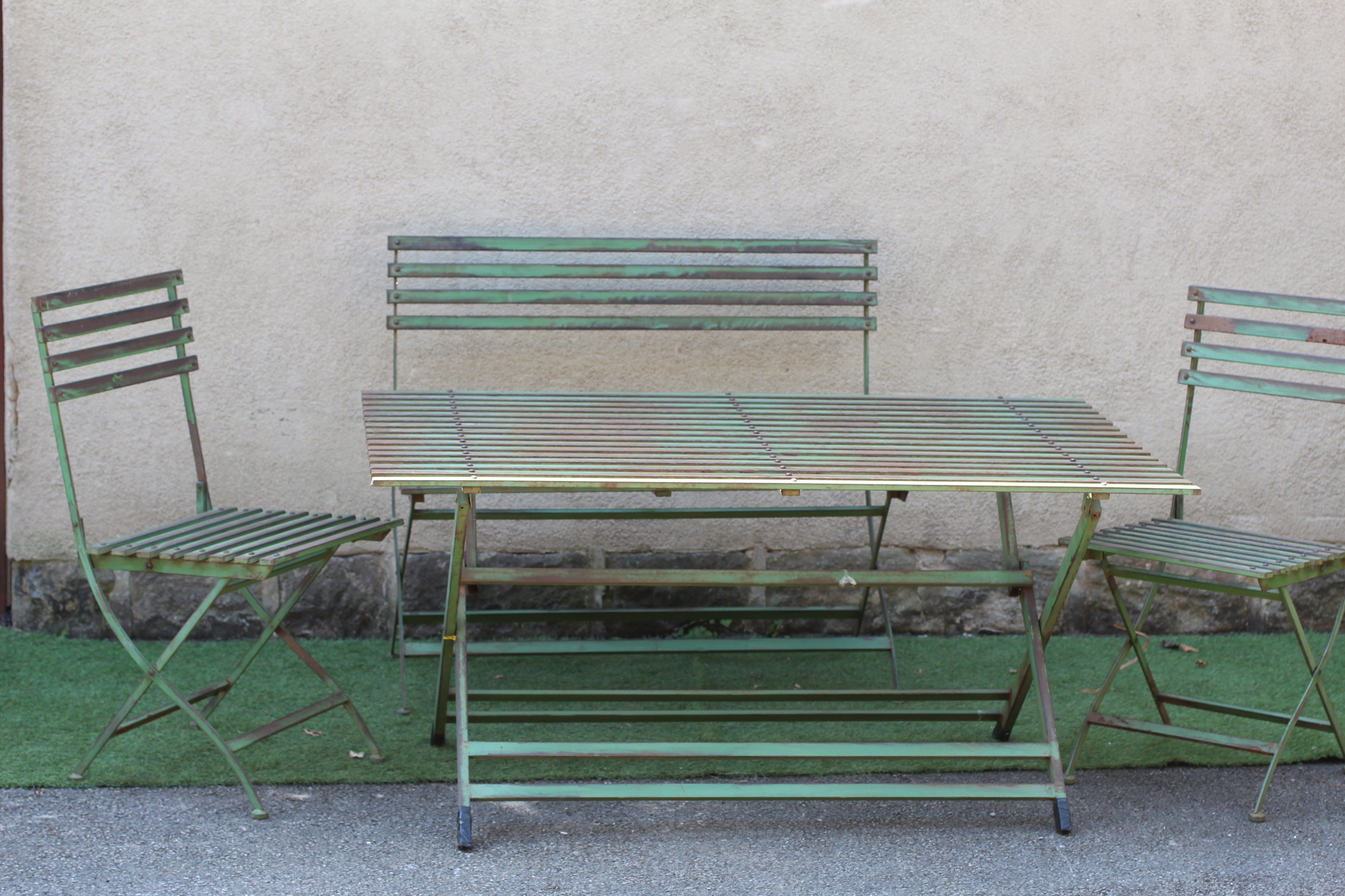 A GREEN PAINTED ALLOY PART DINING SUITE of slatted folding form Image
