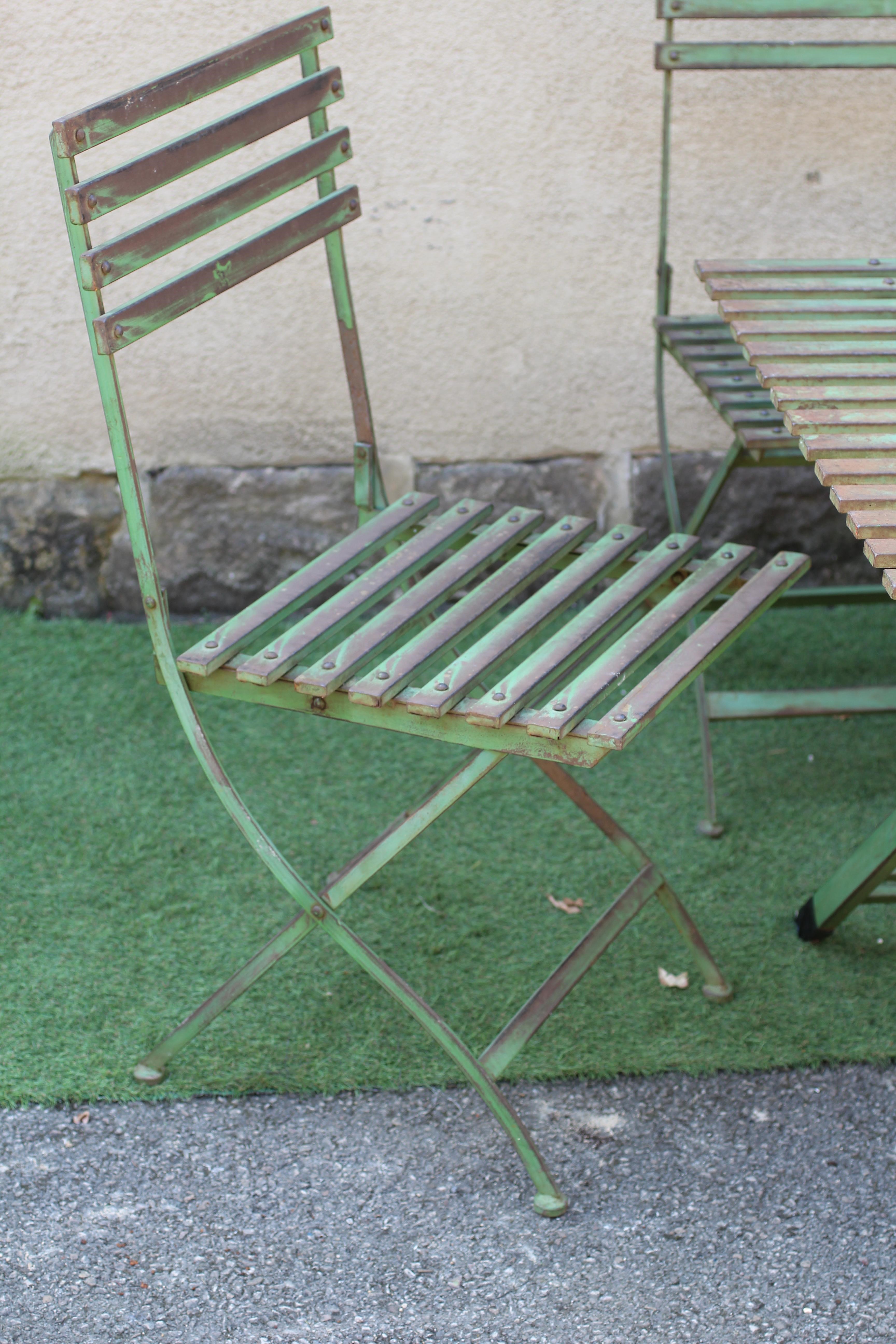 A GREEN PAINTED ALLOY PART DINING SUITE of slatted folding form Image