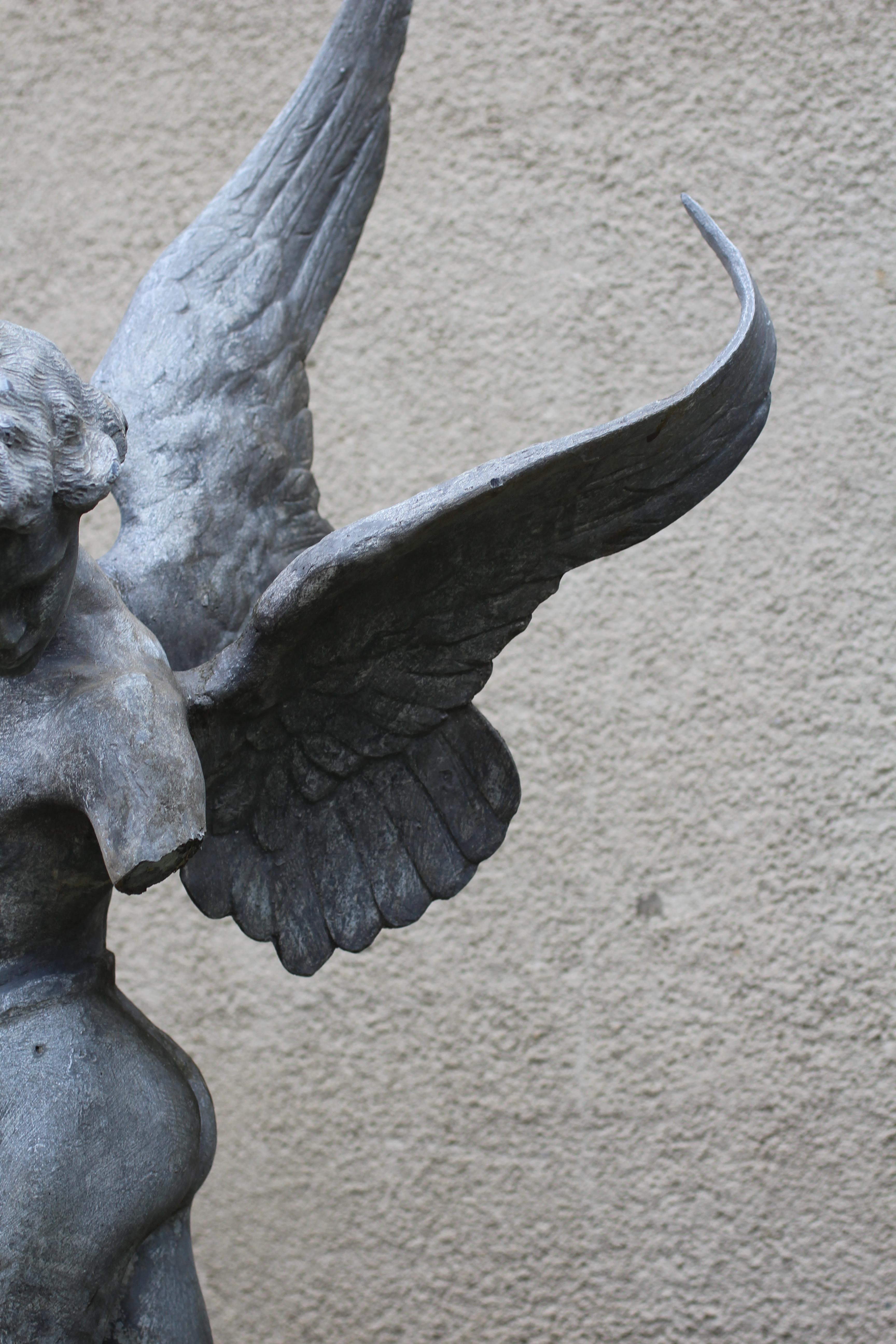 A LEAD FIGURE OF CUPID, modern, modelled standing and firing his arrow, on domed base, 13 1/2" w x Image