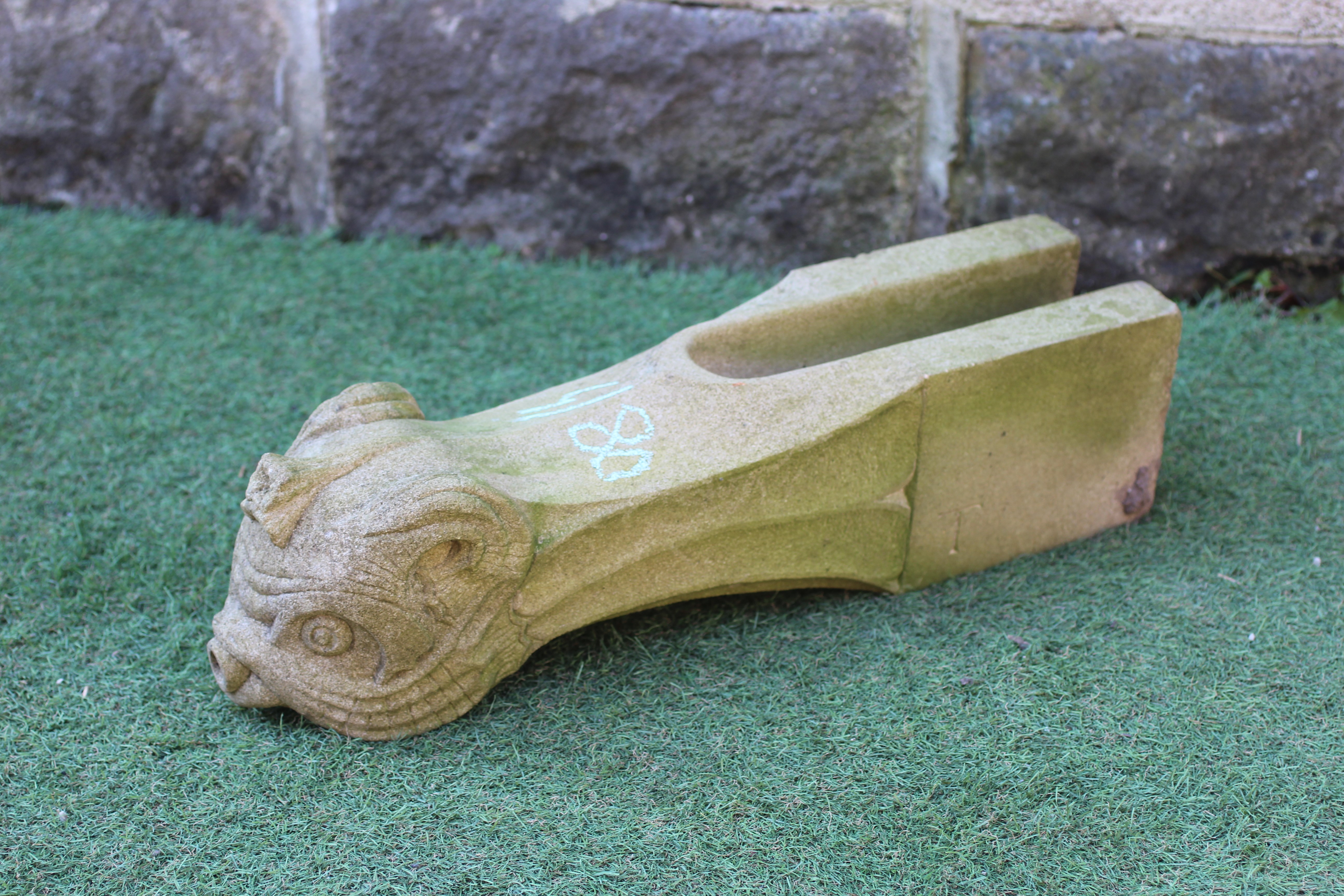 A CARVED SANDSTONE FOUNTAIN SPOUT modelled as the head of a mythical beast, on square base, 23 1/2" Image
