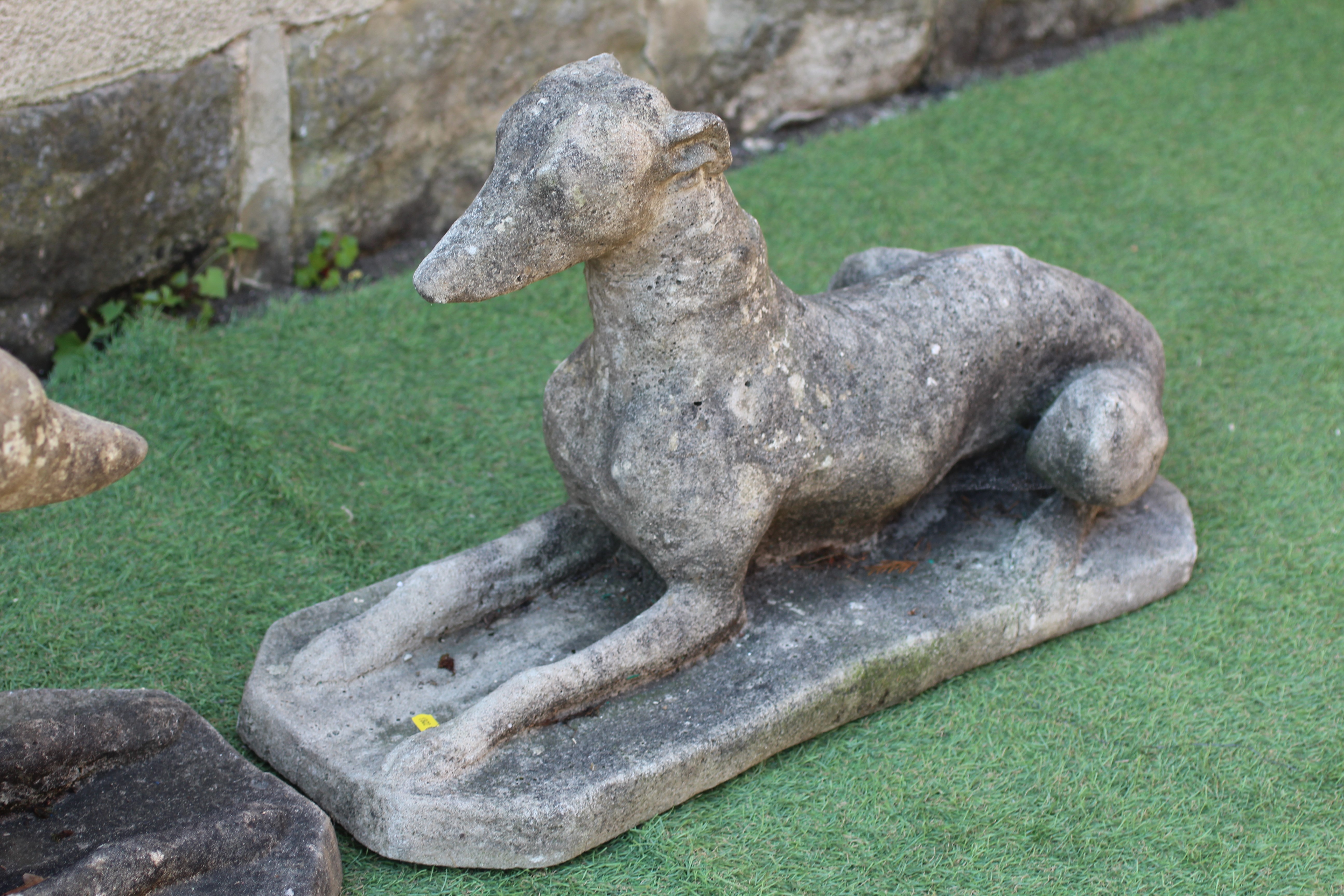 A PAIR OF CAST STONE RECUMBENT WHIPPETS with alert expressions, raised on canted oblong base, 27" w Image