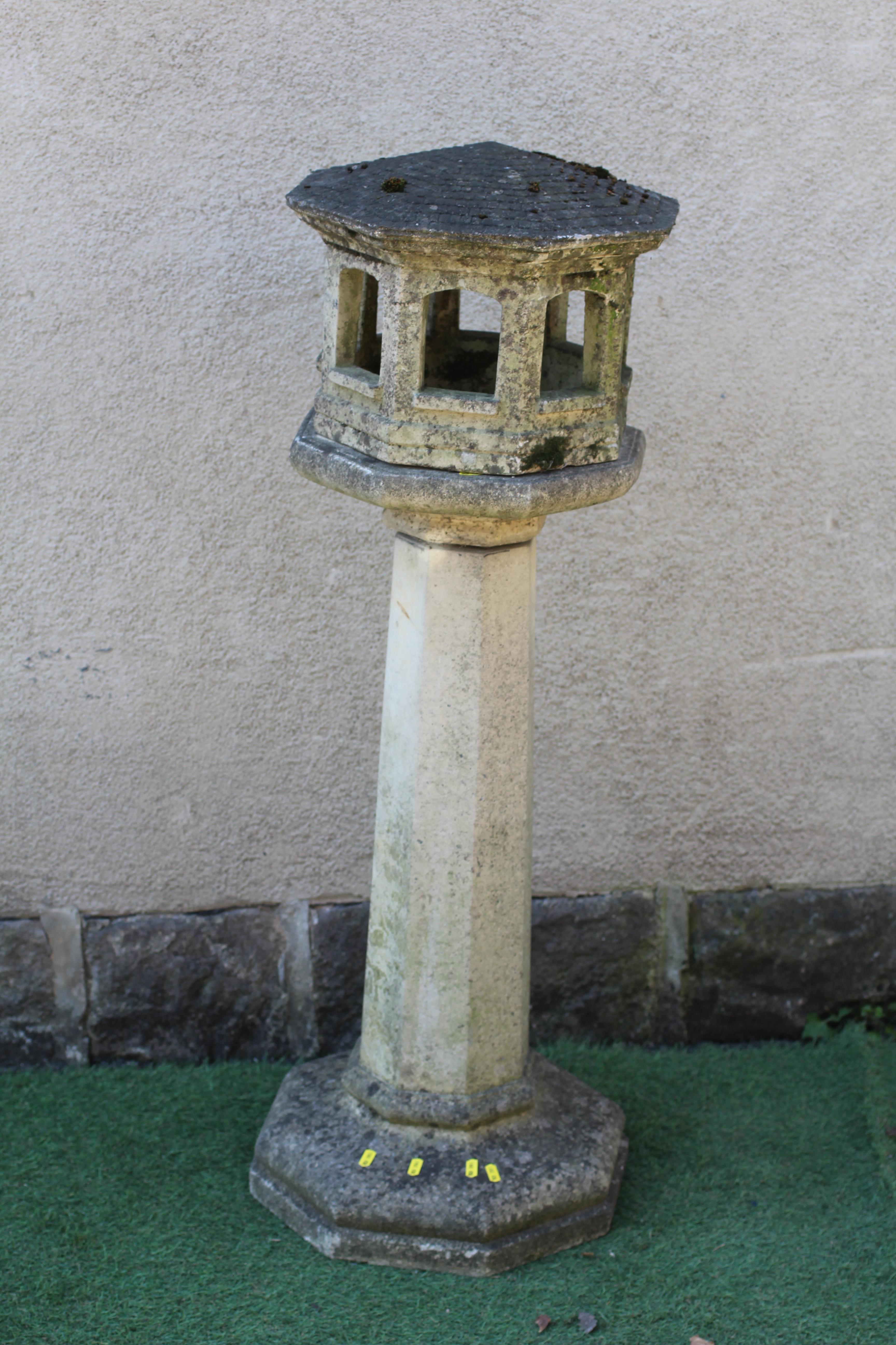 A CAST STONE OCTAGONAL LANTERN, the open sided hood with domed roof, raised on square tapering stem Image