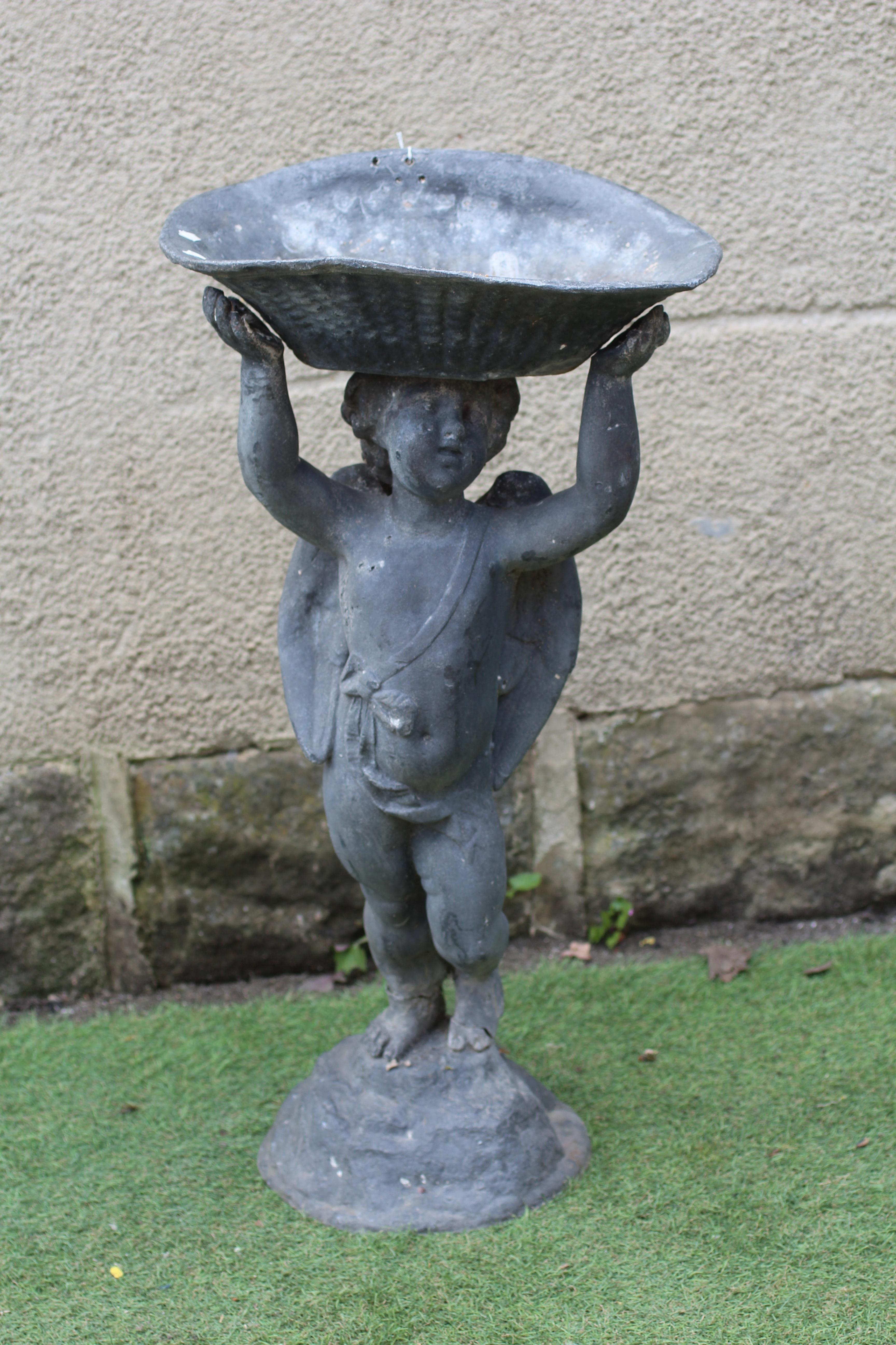 A LEAD FIGURAL BIRD BATH, modern, modelled as a cherub holding aloft a bowl, on domed base, 14 3/4" Image