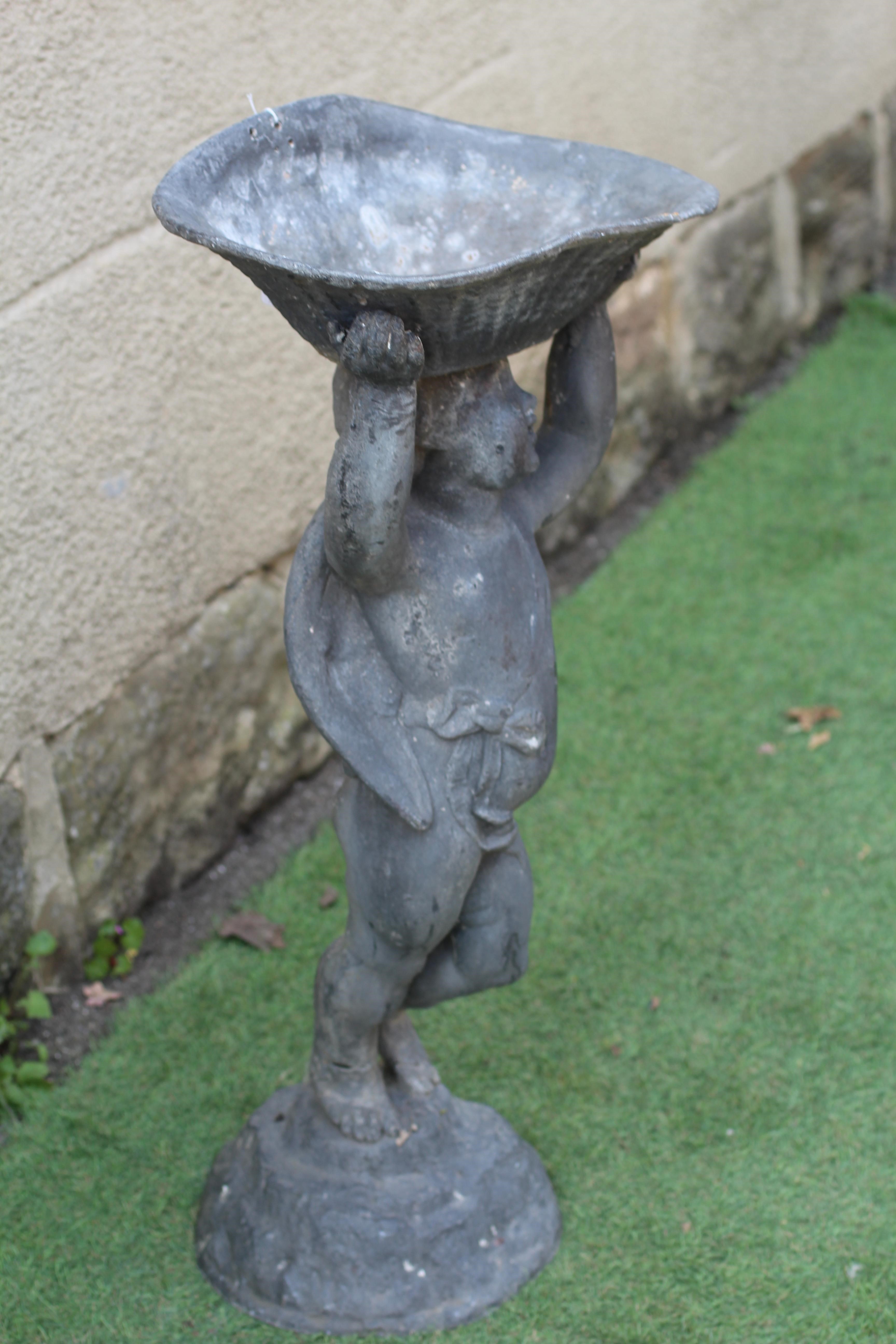 A LEAD FIGURAL BIRD BATH, modern, modelled as a cherub holding aloft a bowl, on domed base, 14 3/4" Image