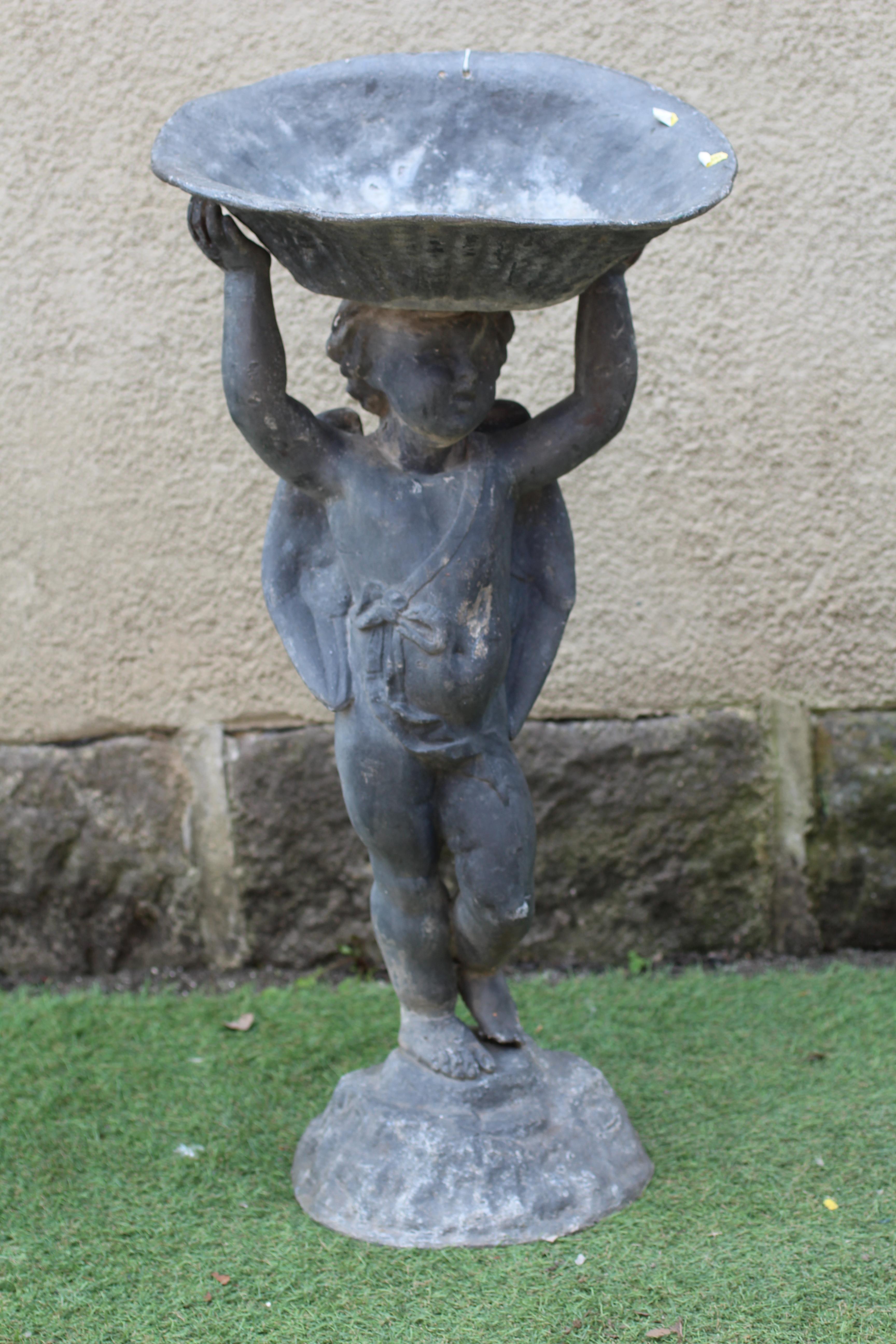 A LEAD FIGURAL BIRD BATH, modern, modelled as a cherub holding aloft a bowl, on domed base, 14 3/4" Image